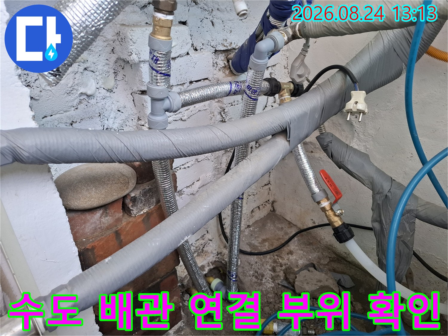 다양한 규격의 수도 배관과 밸브가 연결된 보일러실 내부 전경