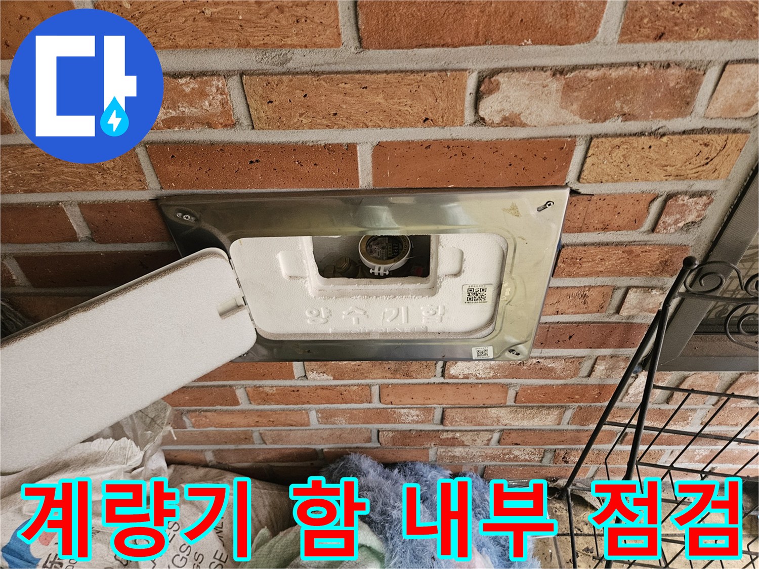벽돌-사이-설치된-수도-계량기-함을-열어-점검하는-모습
