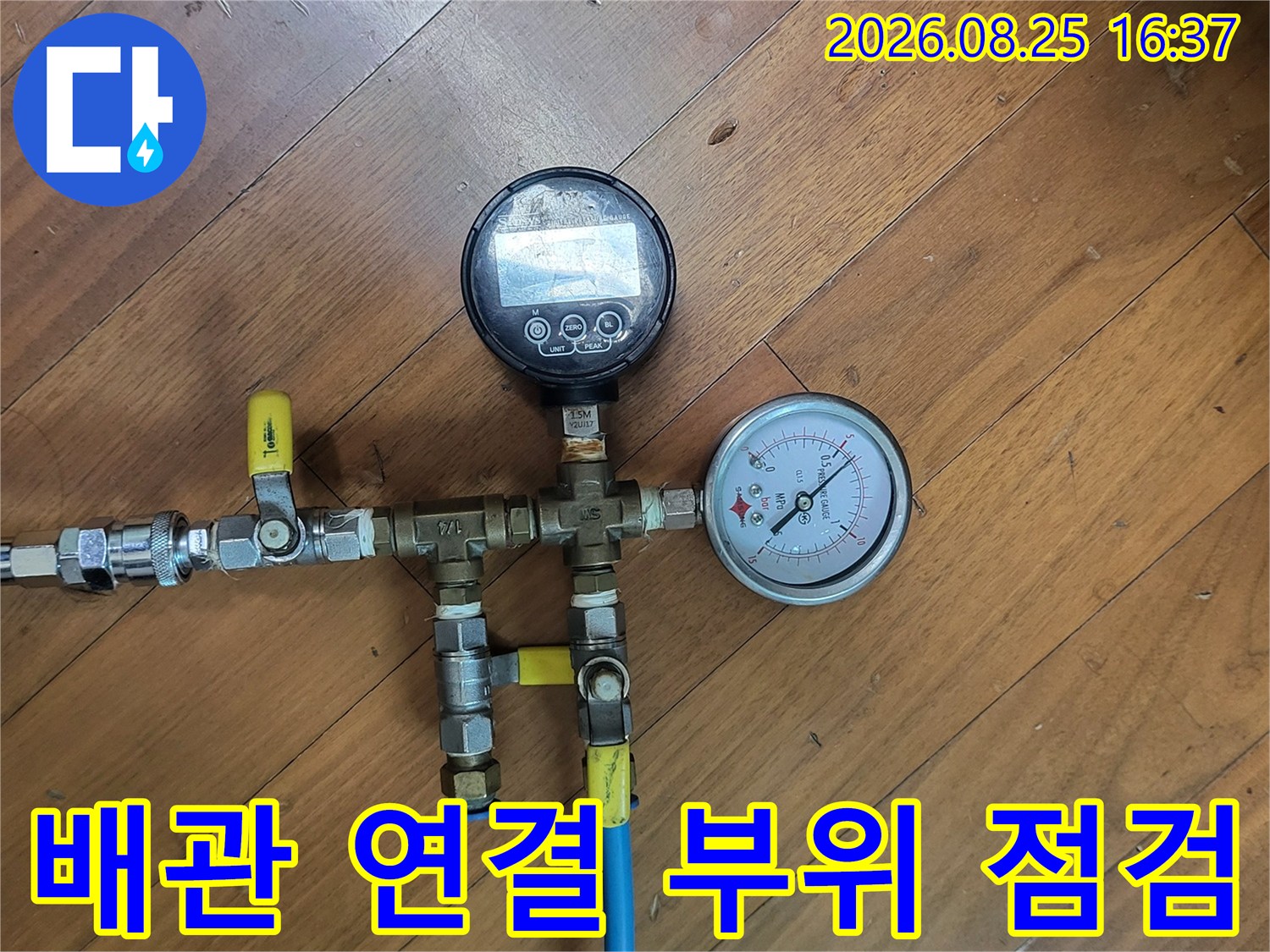 나무 바닥 위 설치된 - 배관 압력 측정용 밸브와 호스