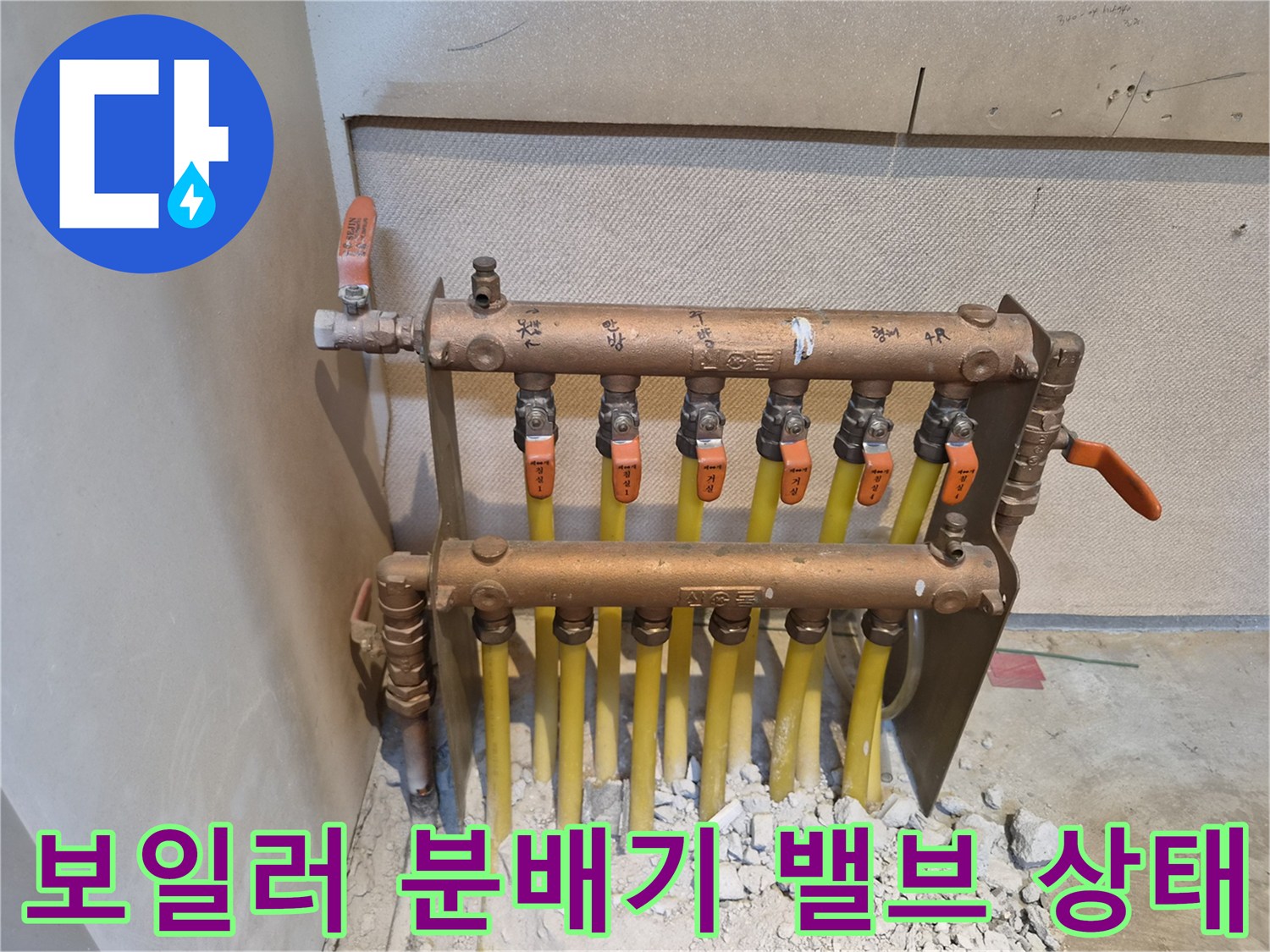주황색 손잡이가 달린 분배기 밸브와 연결된 배관들입니다.