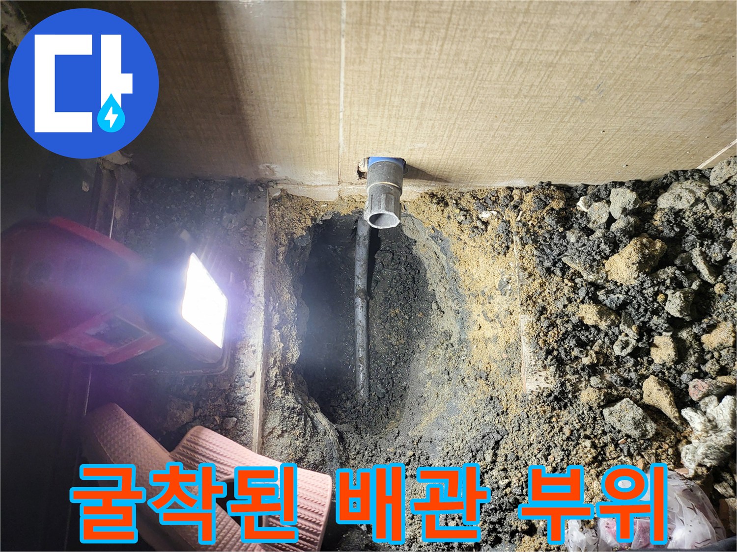 바닥 굴착 후 드러난 오수 배관과 주변 토사 상태
