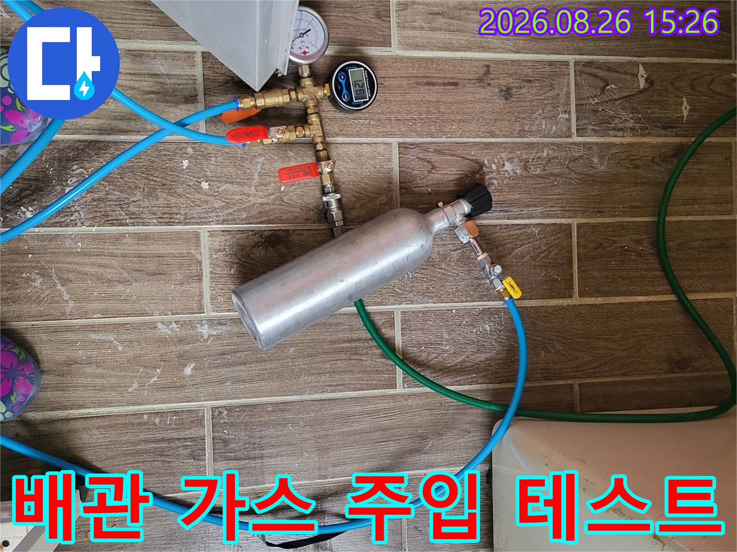 배관의 압력을 측정하기 위해-게이지와 가스통을-연결하여 점검 중인 모습
