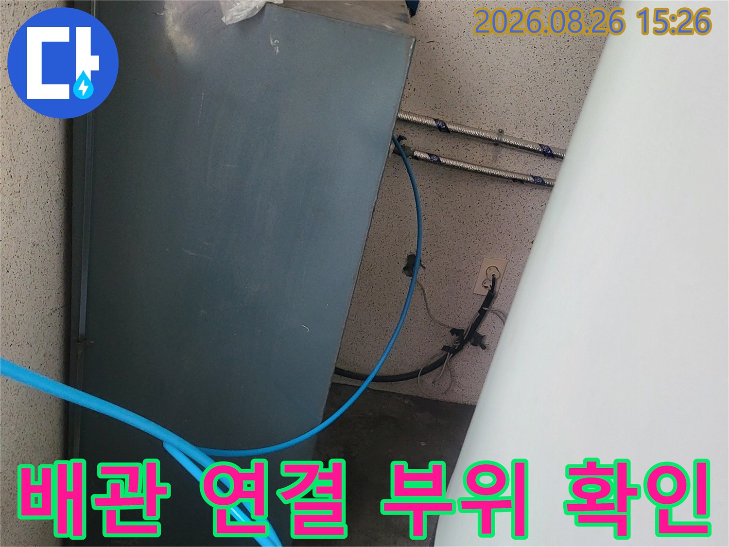 어두운 배관 공간에 놓인 파란색 호스와 금속 배관-정밀 진단 중