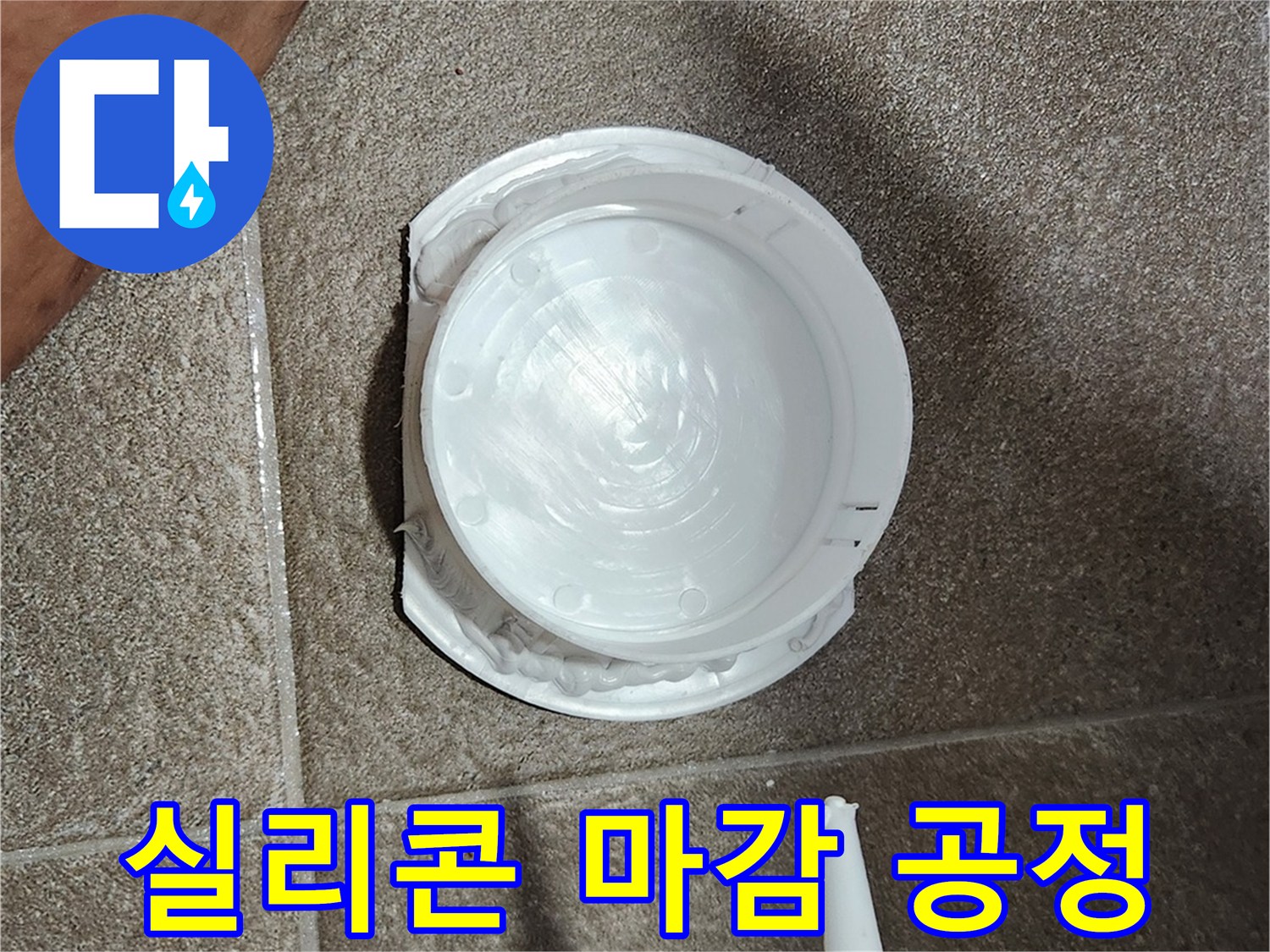점검구 가장자리에 하얀색 실리콘을 쏘아 마무리하는 모습입니다.