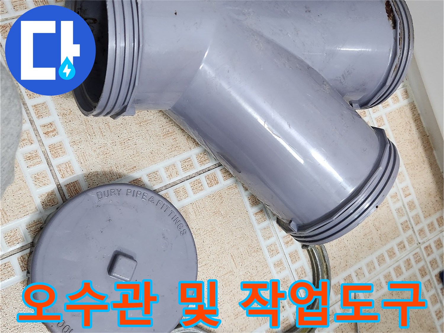 탈거된 회색 배관 부속과 클램프가 있는 작업 현장입니다.