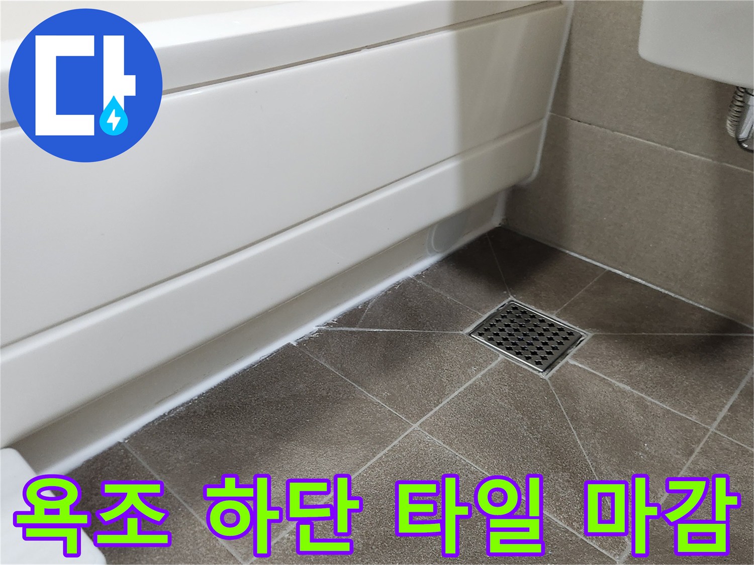 흰색 욕조 측면과 갈색 타일 바닥이 만나는 지점의 배수구 상세
