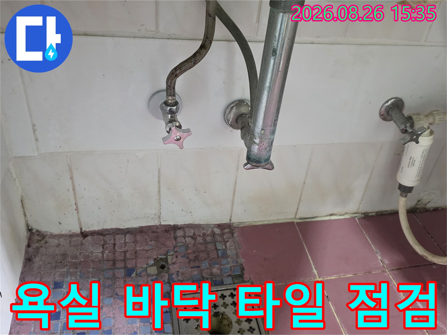하수구 배수구 주변의 타일 마감 상태와 배관 연결부를 근접 촬영한 모습입니다.