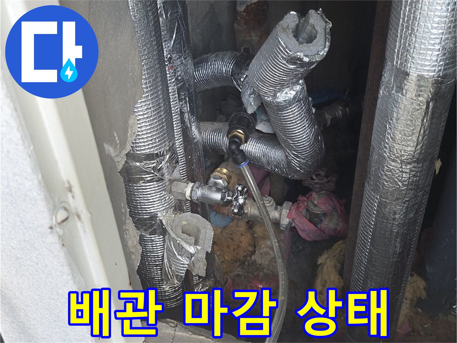 은박 보온재로 덮인 배관의 연결 지점을 보여주는 사진입니다.