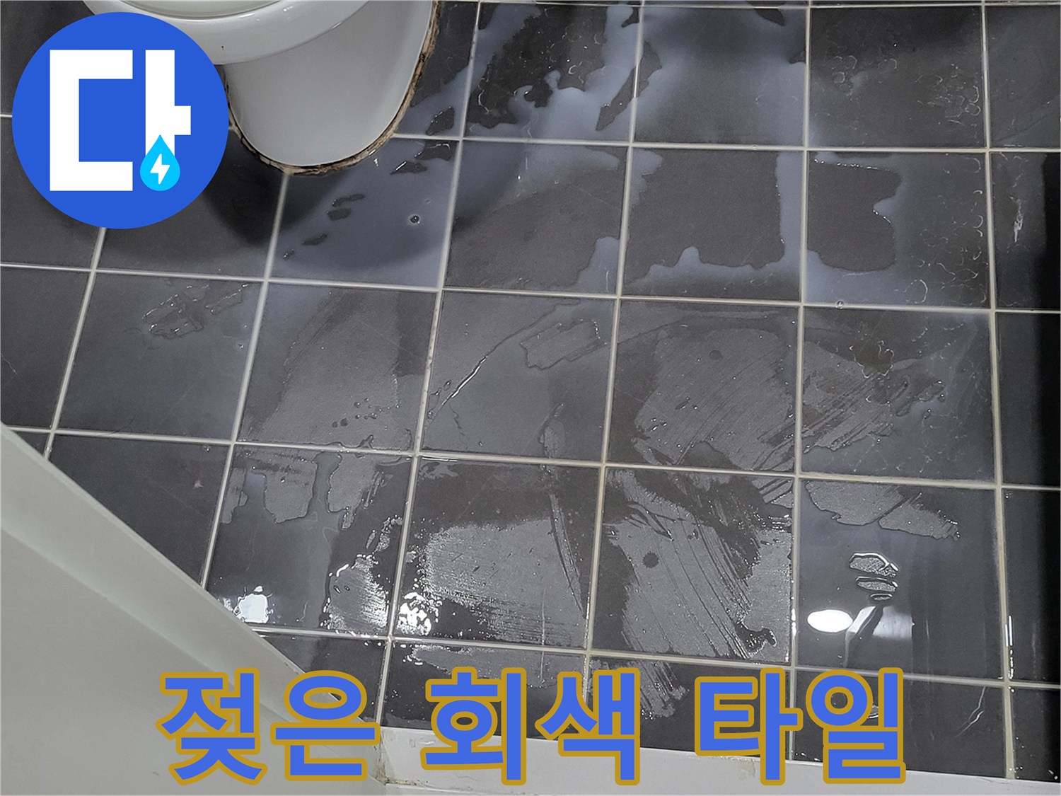 물기가 맺혀 있는 어두운 색 타일 바닥