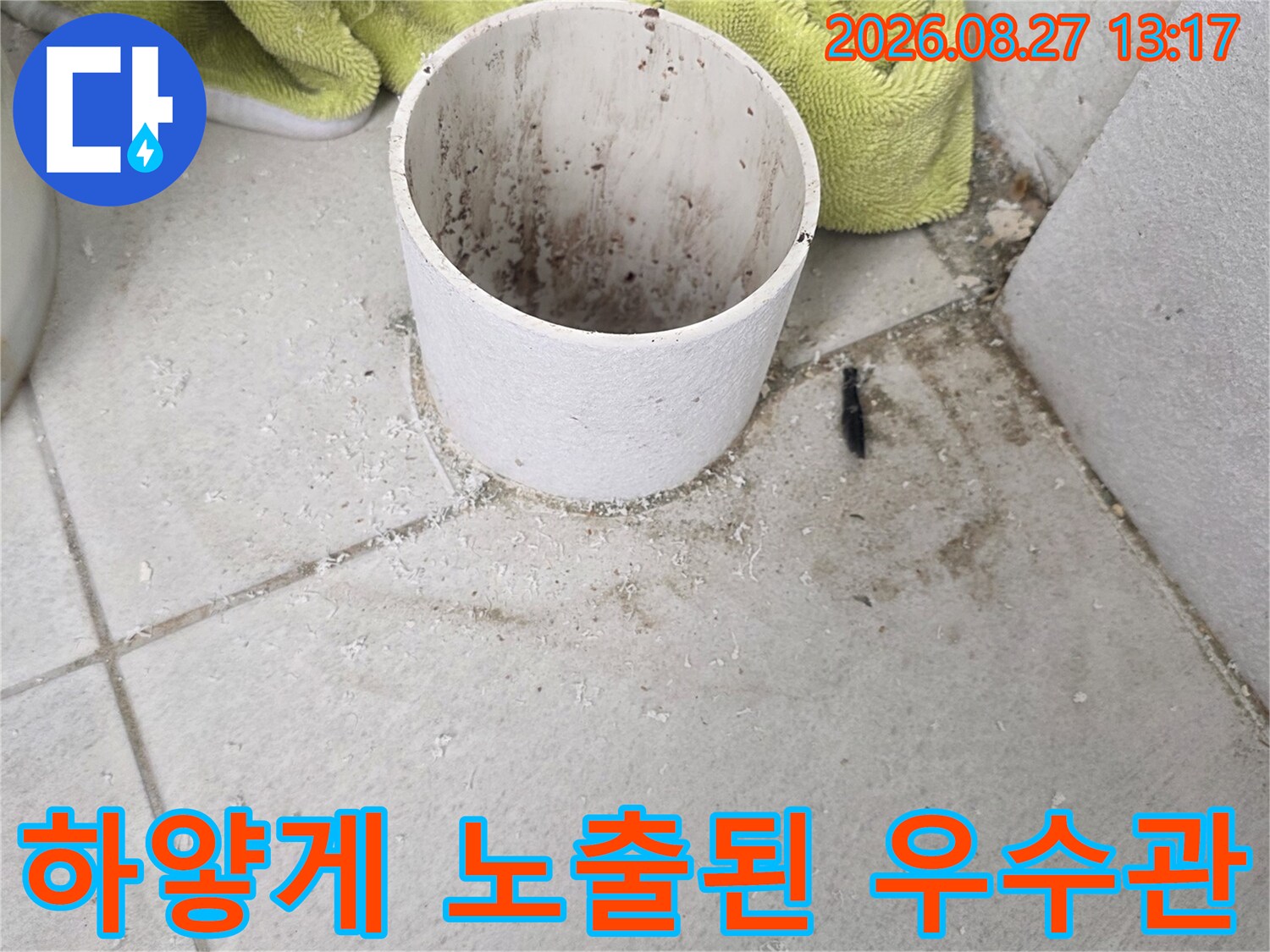 바닥 타일에서 올라온 하얀색 우수관 배관의 입구 모습입니다.
