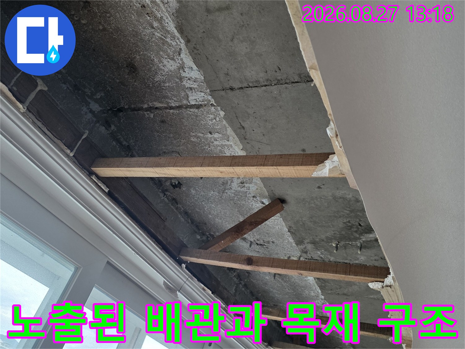베란다 창틀 하단에 노출되어 있는 배관 및 보강용 목재 프레임
