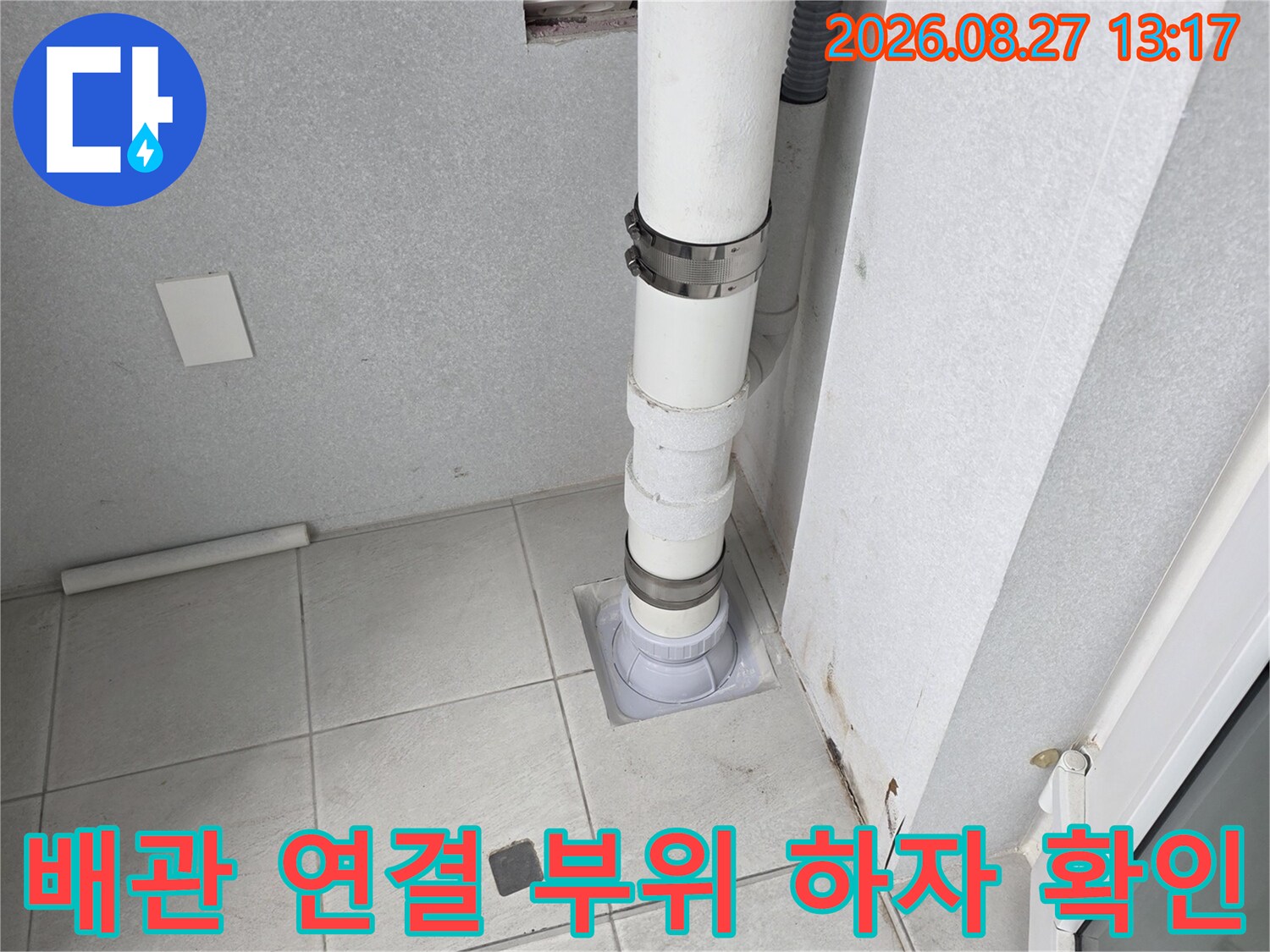 우수관 배관과 벽면 타일 사이의 연결 상태 점검 중