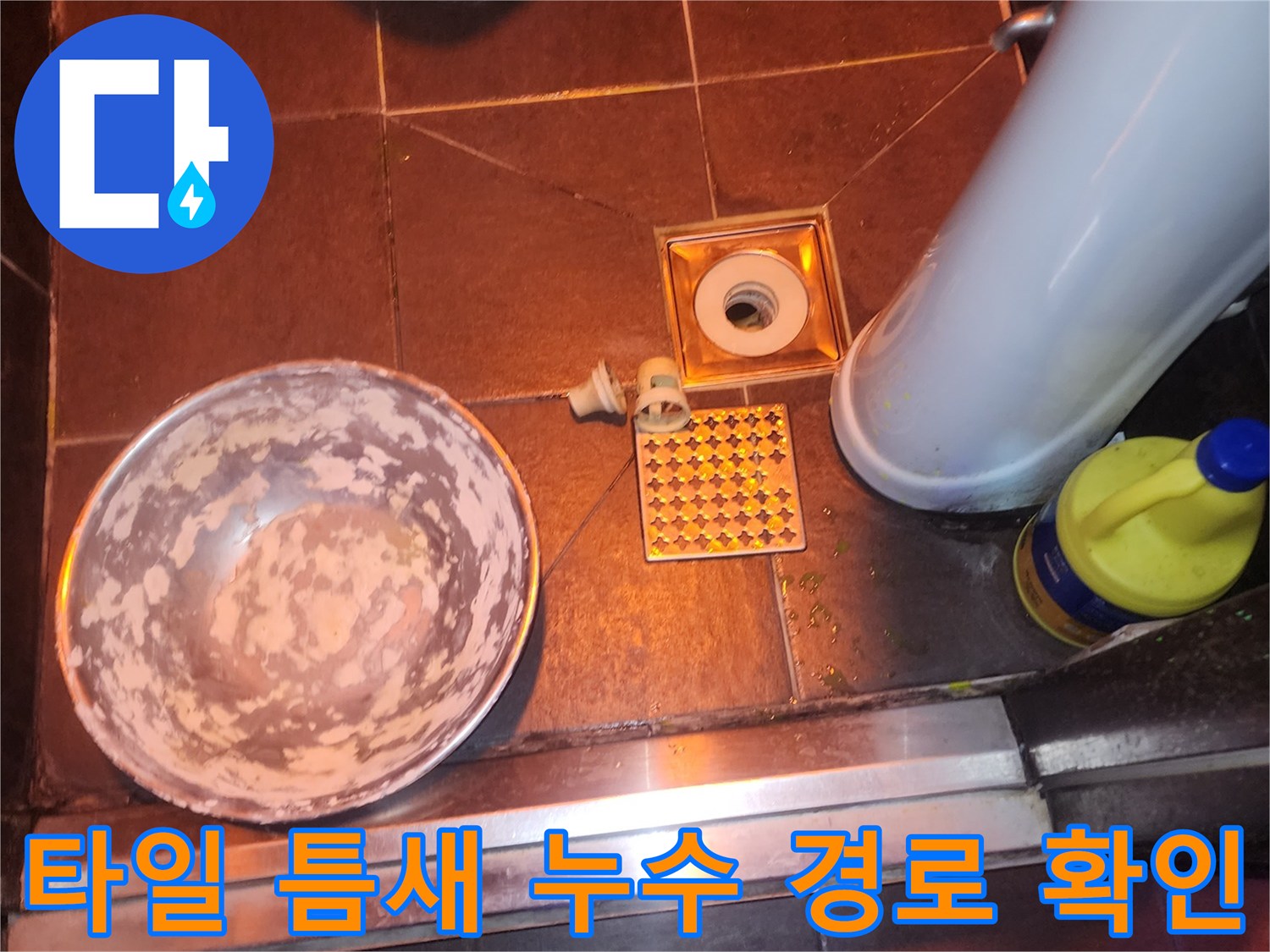 바닥 타일 사이의 갈라진 틈과 배수구 주변을 근접 촬영한 모습입니다.