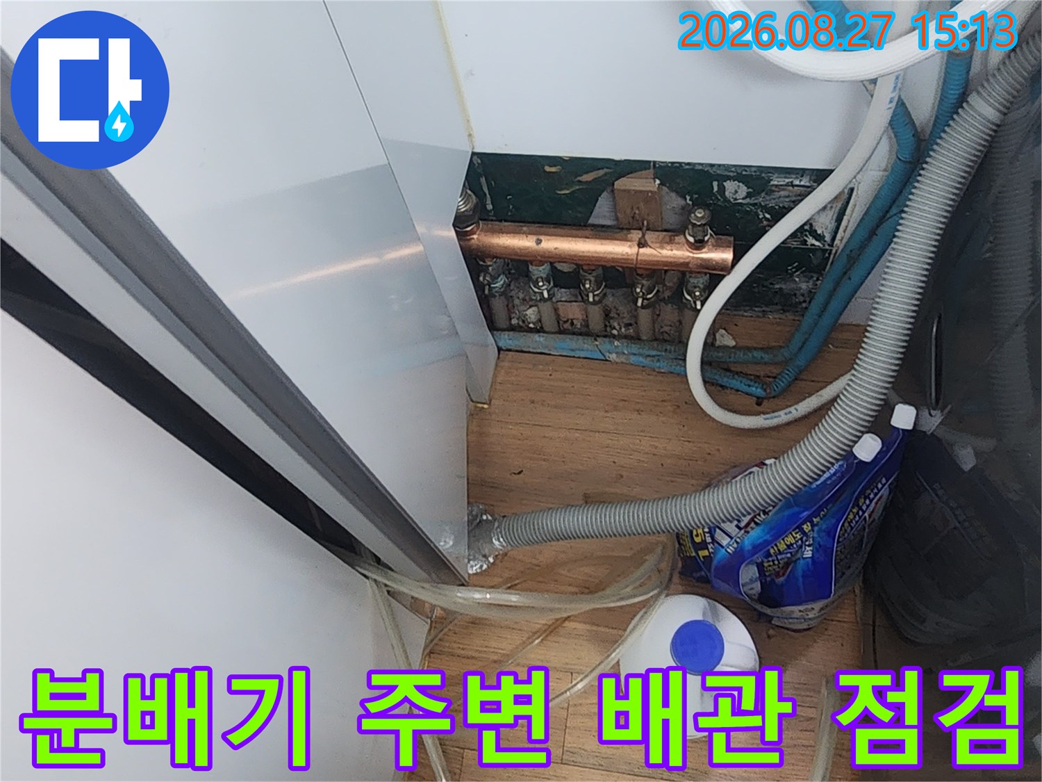 보일러 분배기와-연결된 굵은 배관과 투명 호스들을 상세히 촬영한 사진입니다.