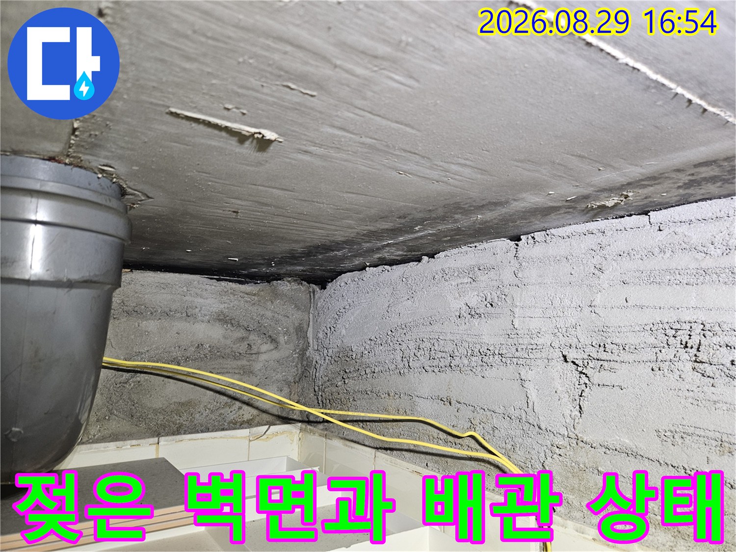 상계동 현장의-습기가 찬 콘크리트 벽면과 천장 배관의 모습입니다.