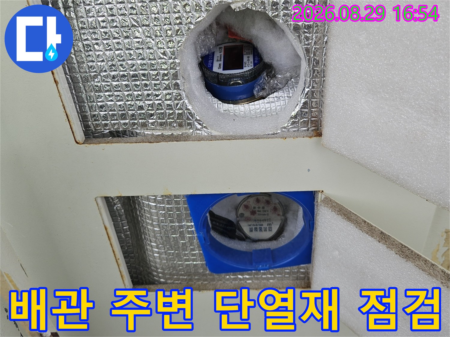 은박 단열재로 덮인 계량기 함 내부의 배관 연결 부위 상세 사진입니다.
