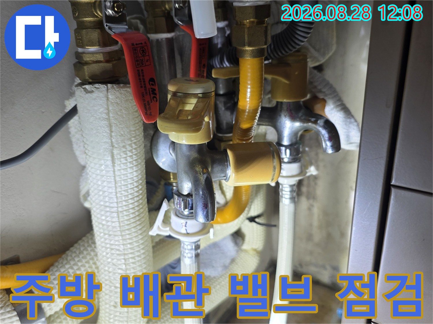 노란색 보온재로 감싸진 수도 배관과 금속 수전 밸브의 근접 사진입니다.
