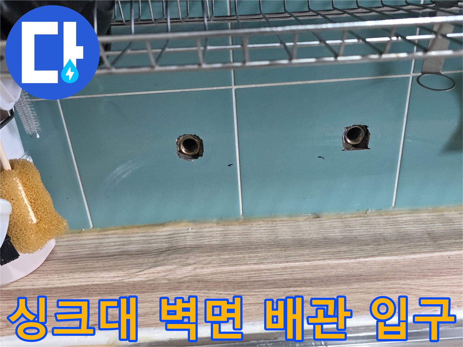싱크대 하단 타일 벽면에 노출된 수도 배관 연결 부위