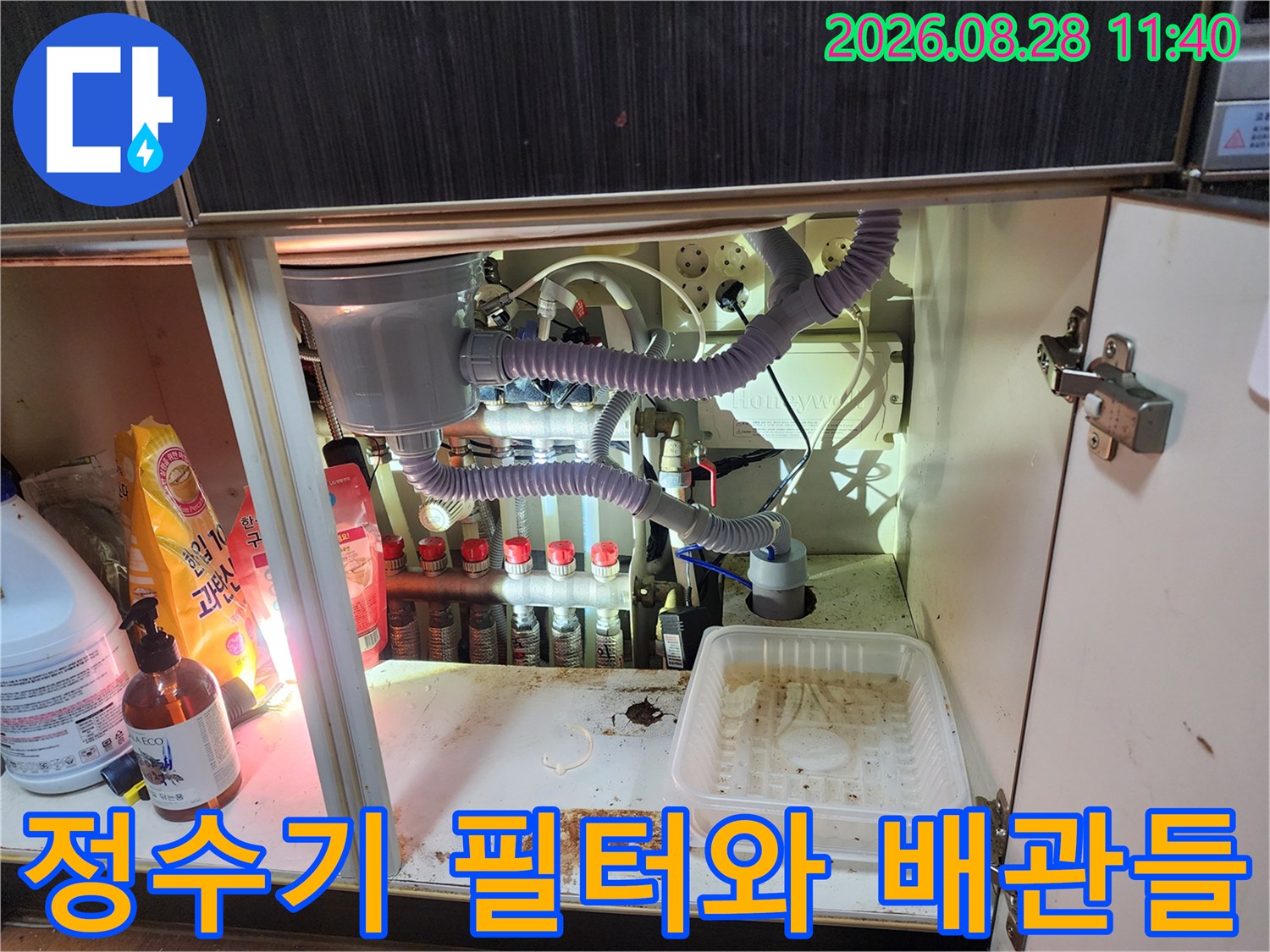 주방 싱크대 하단에 설치된 정수기 필터와 연결 호스 배열