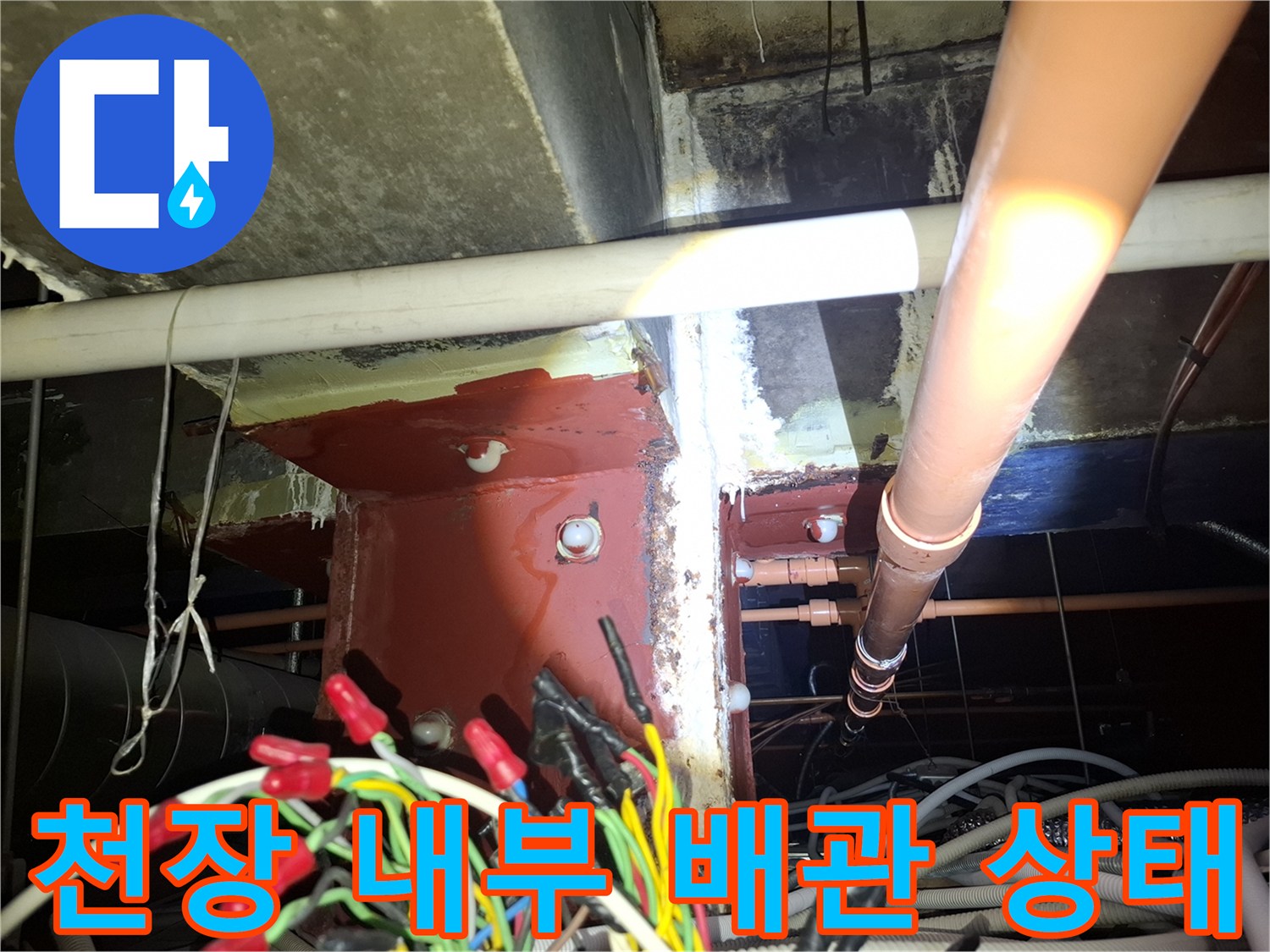 천장 텍스 안쪽의 흰색 배관과 습기가 스며든 기둥 구조물