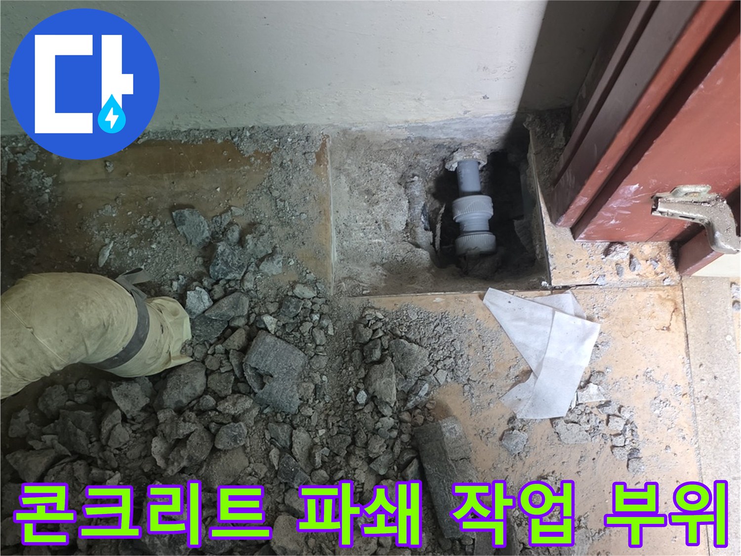 거실 바닥을 깨서 배관의 누수 지점을 노출시킨 현장 사진입니다.