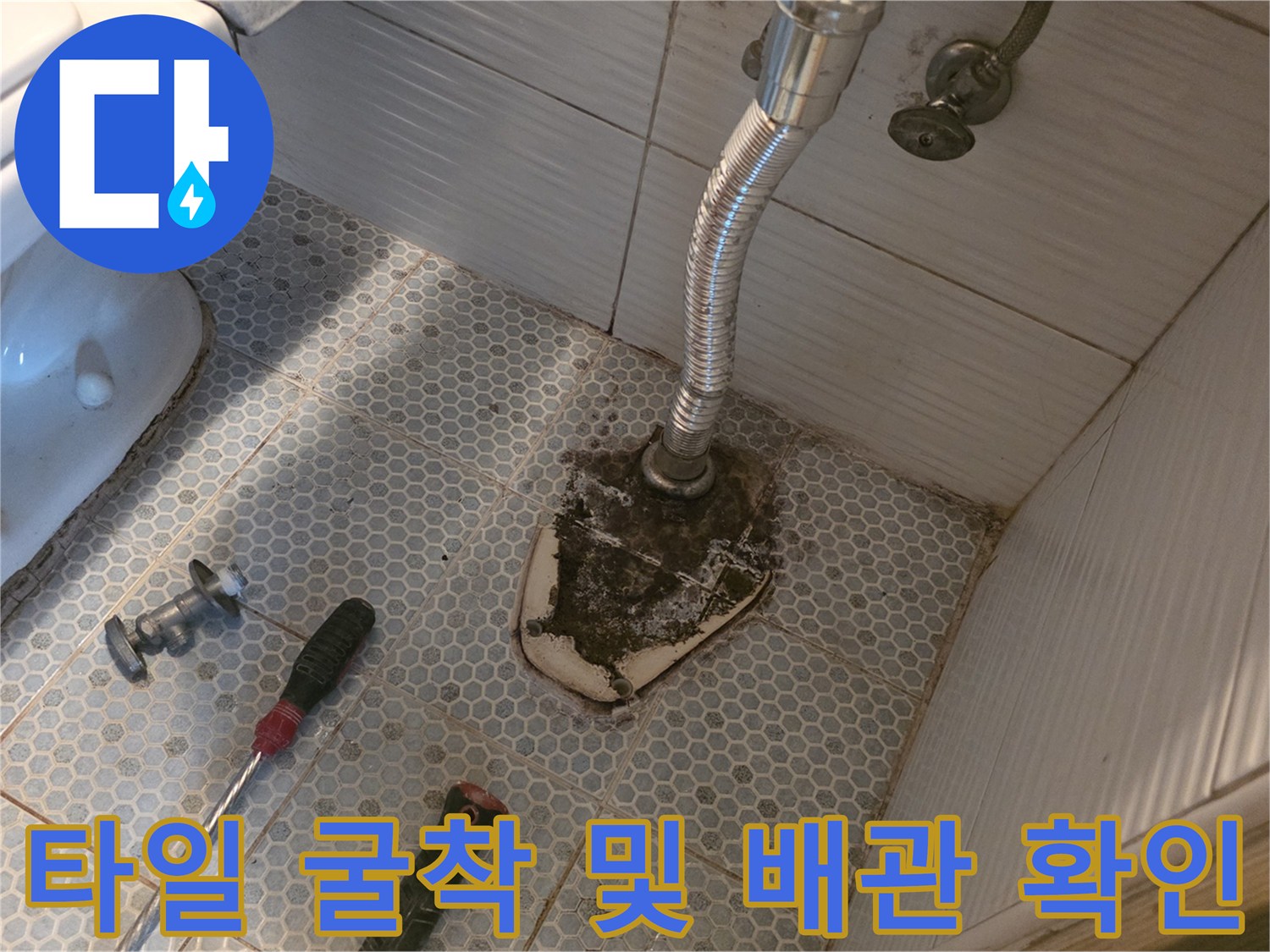 화장실 변기 옆 타일 제거 후 노출된 배관과 공구들