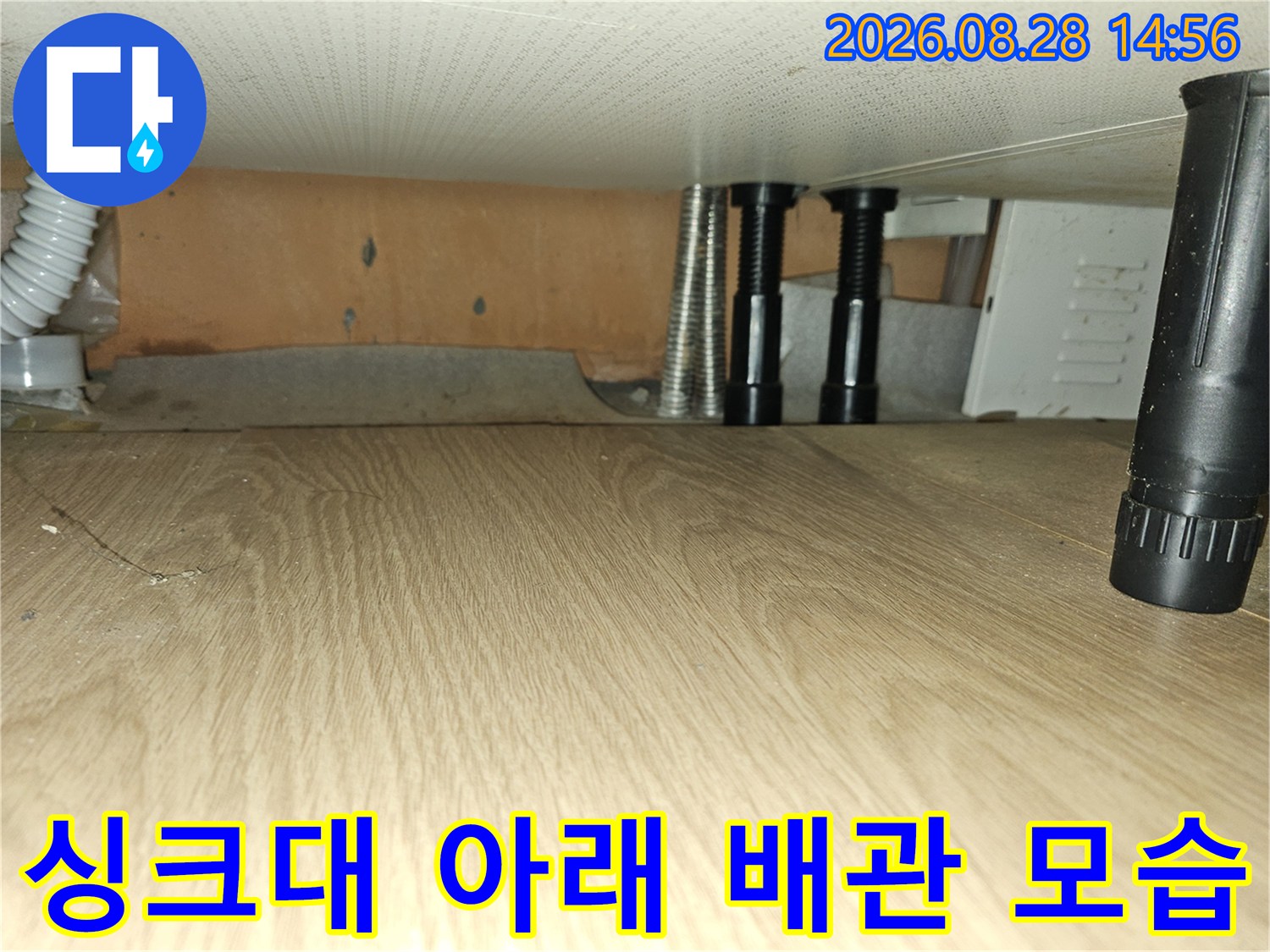 싱크대 하부의 흰색 주름관과 검은색 지지 구조물
