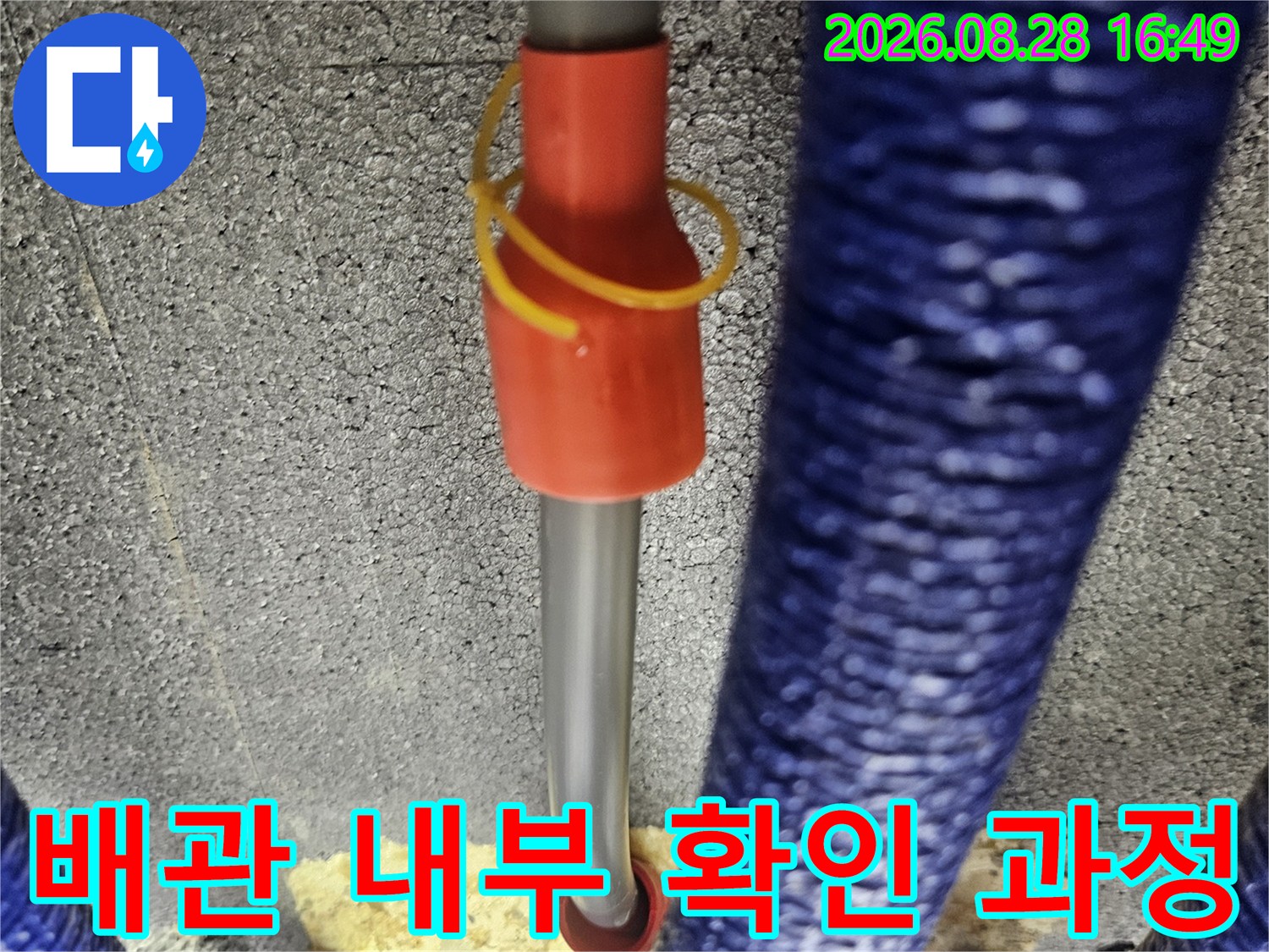 타공된 틈을 통해 보이는 푸른색 보온재와 내시경 장비