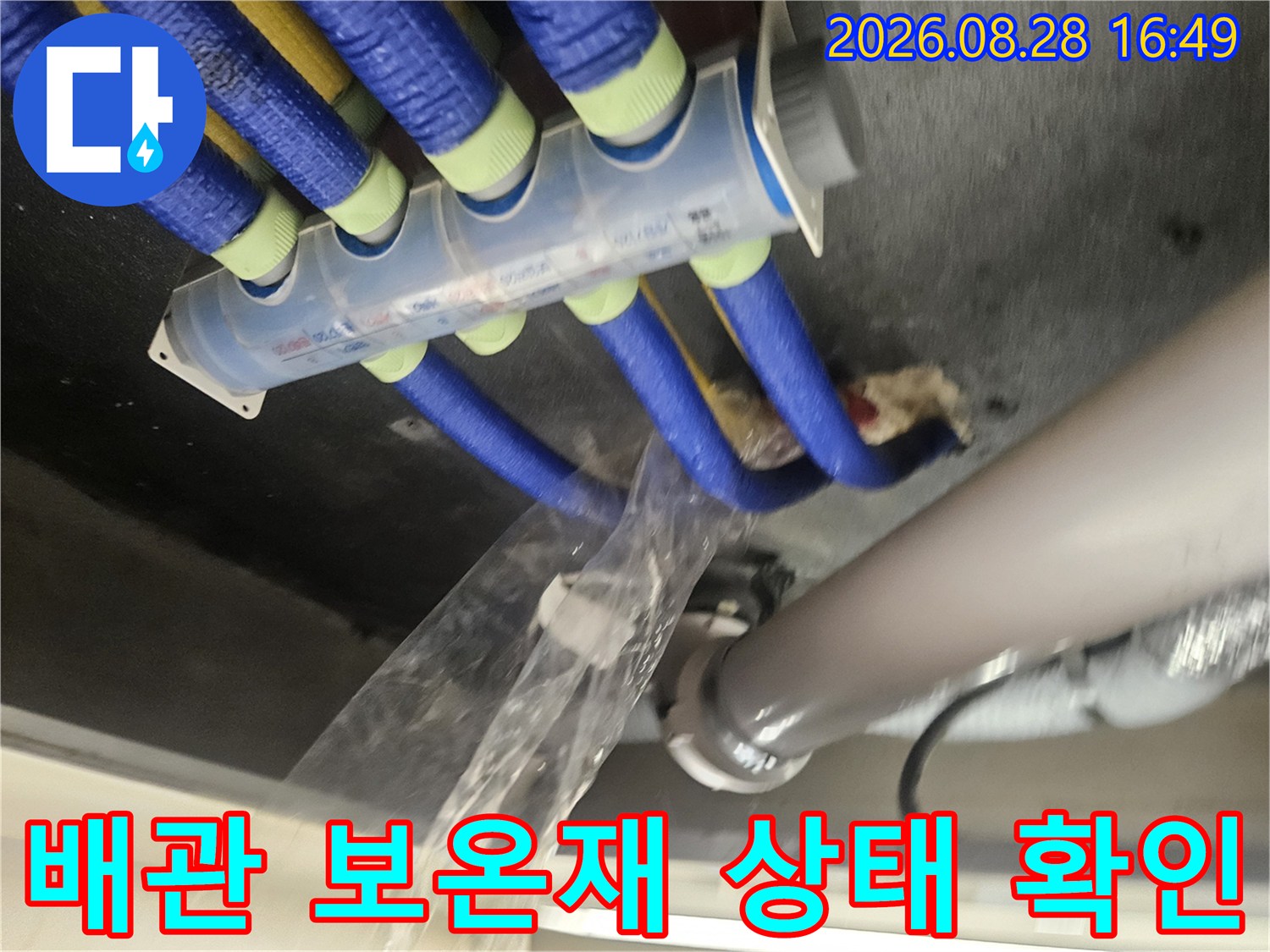 푸른색 보온재로 감싸진 배관과 천장 내부 모습