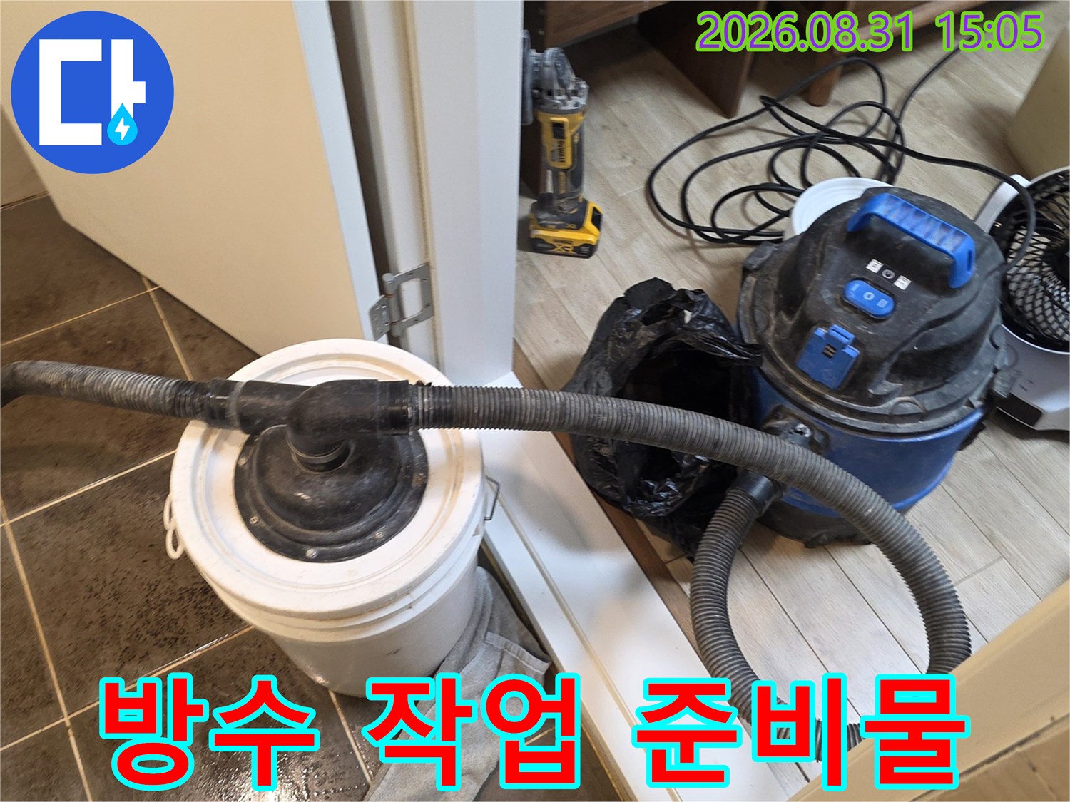 욕실 방수 보강 작업을 위해 배치된 집진기와 배수 용기