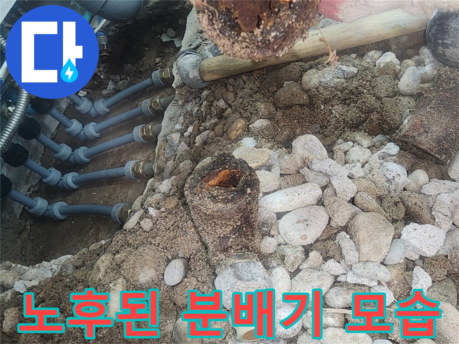자갈과 흙 사이로 노출된 노후된 금속제 배관