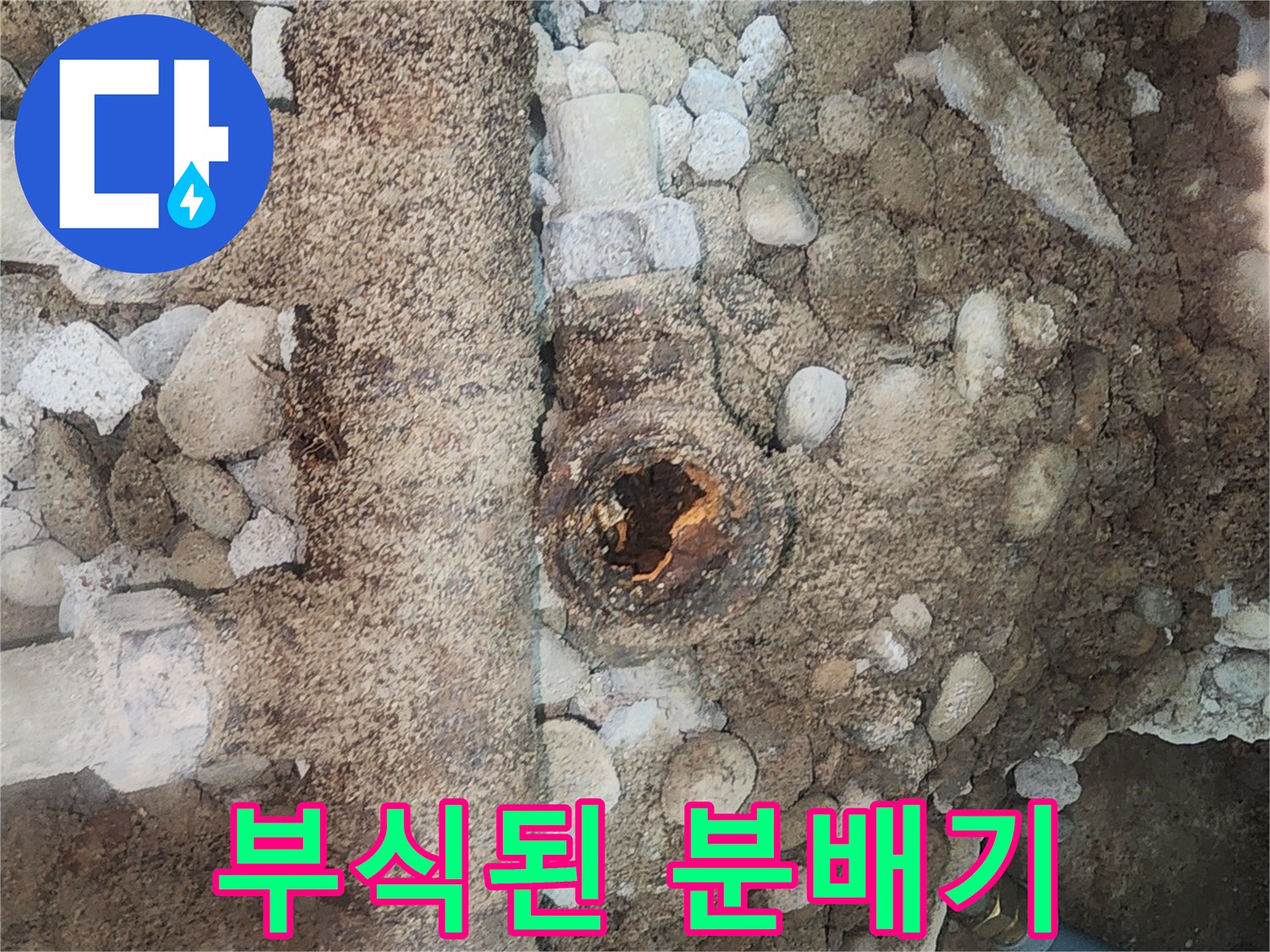 자갈과 흙 사이로 드러난 부식된 금속 분배기 모습