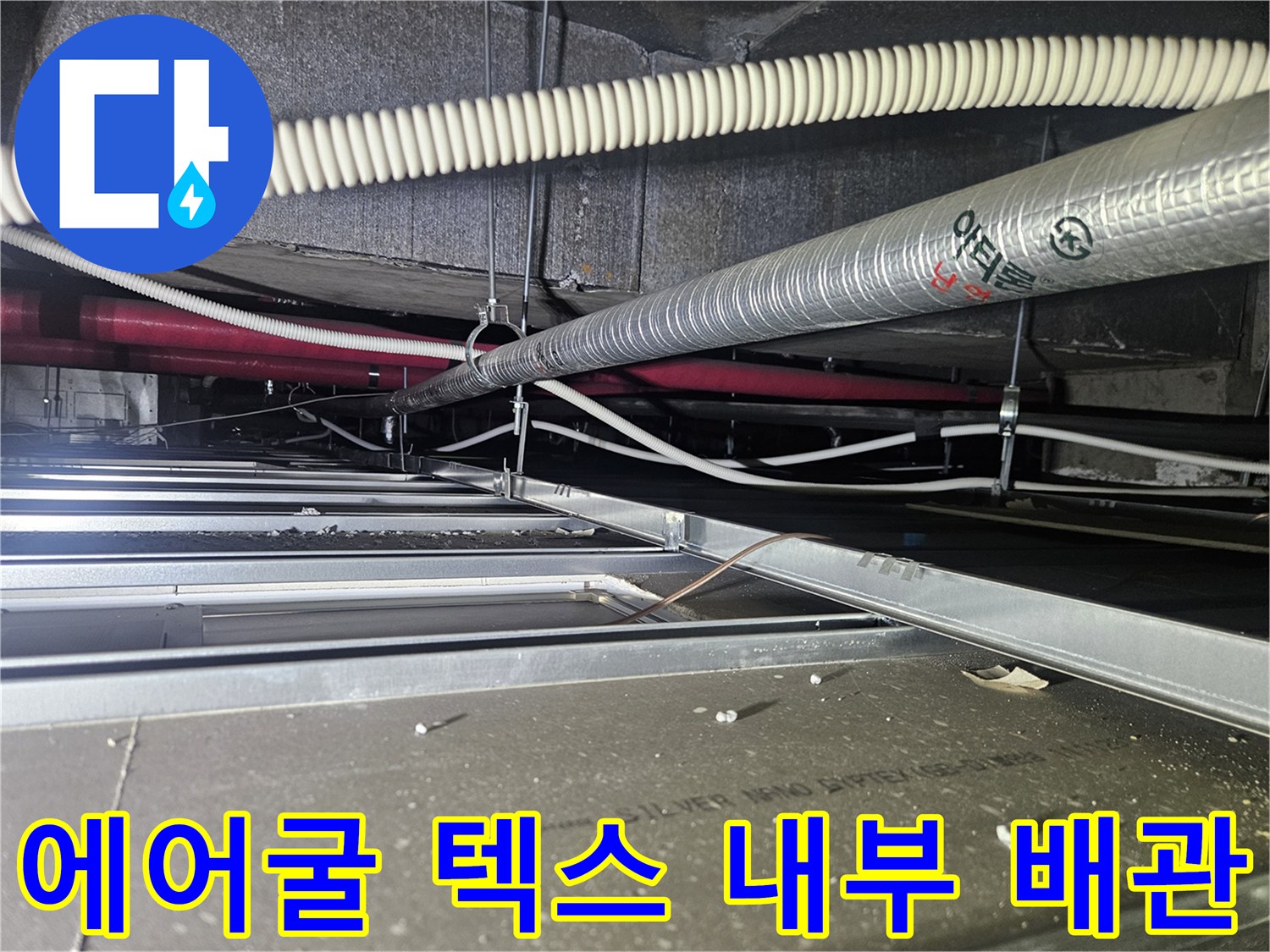 천장 내부-배수 호스와 은색 보온재로 마감된 공조 배관의 모습