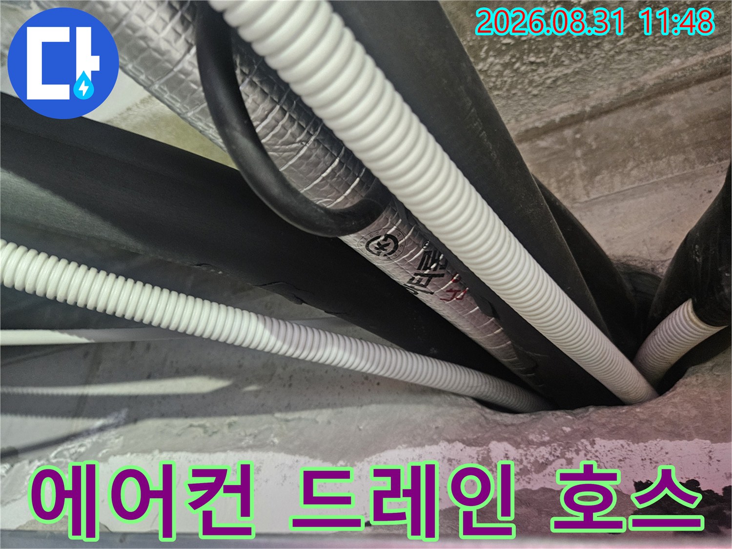 천장 내부-주름진 배수 호스와 보온재가 설치된 모습