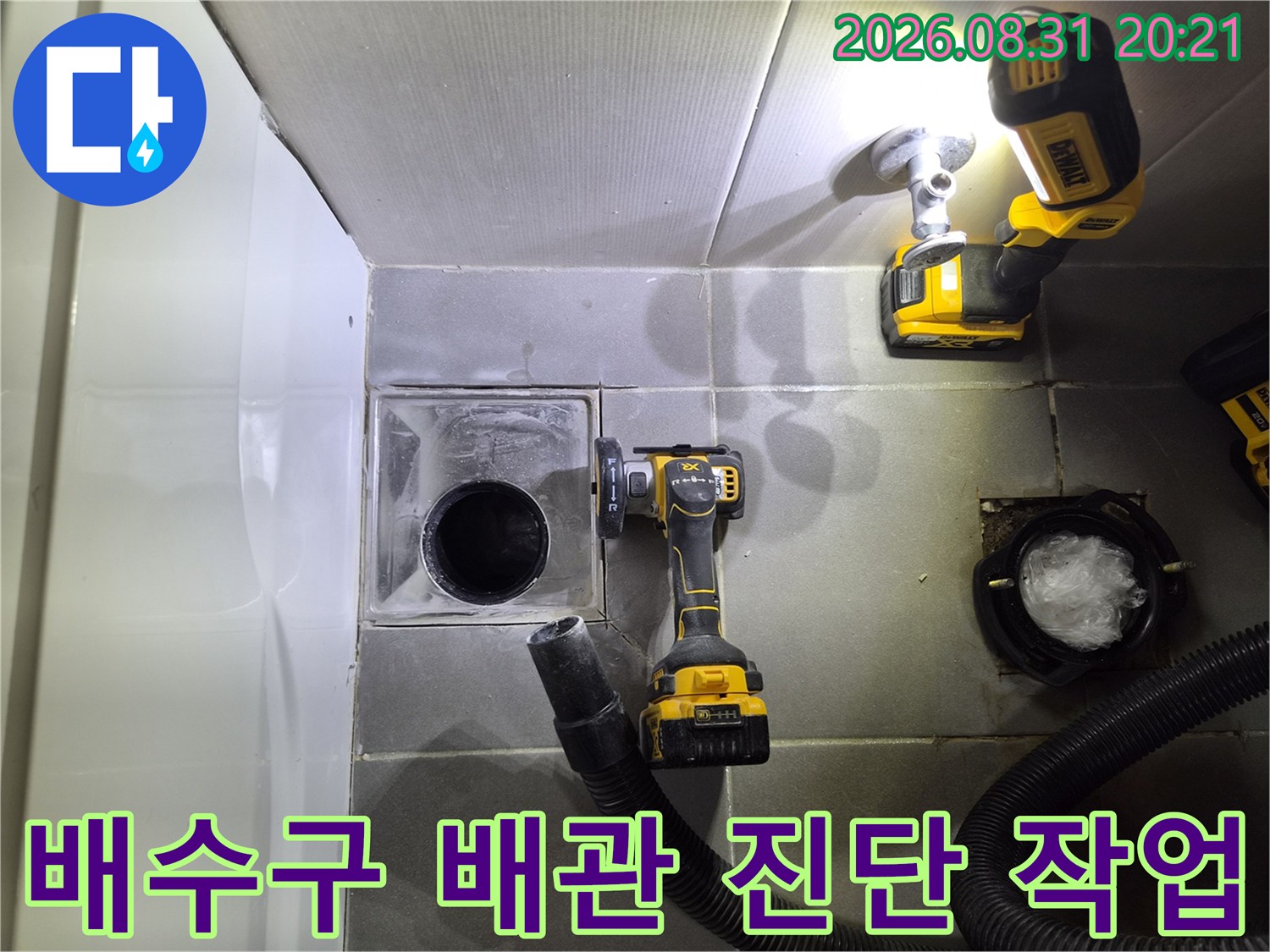 노출된 배수구 주변의 상태와 청소용 장비를 보여주는 사진입니다.