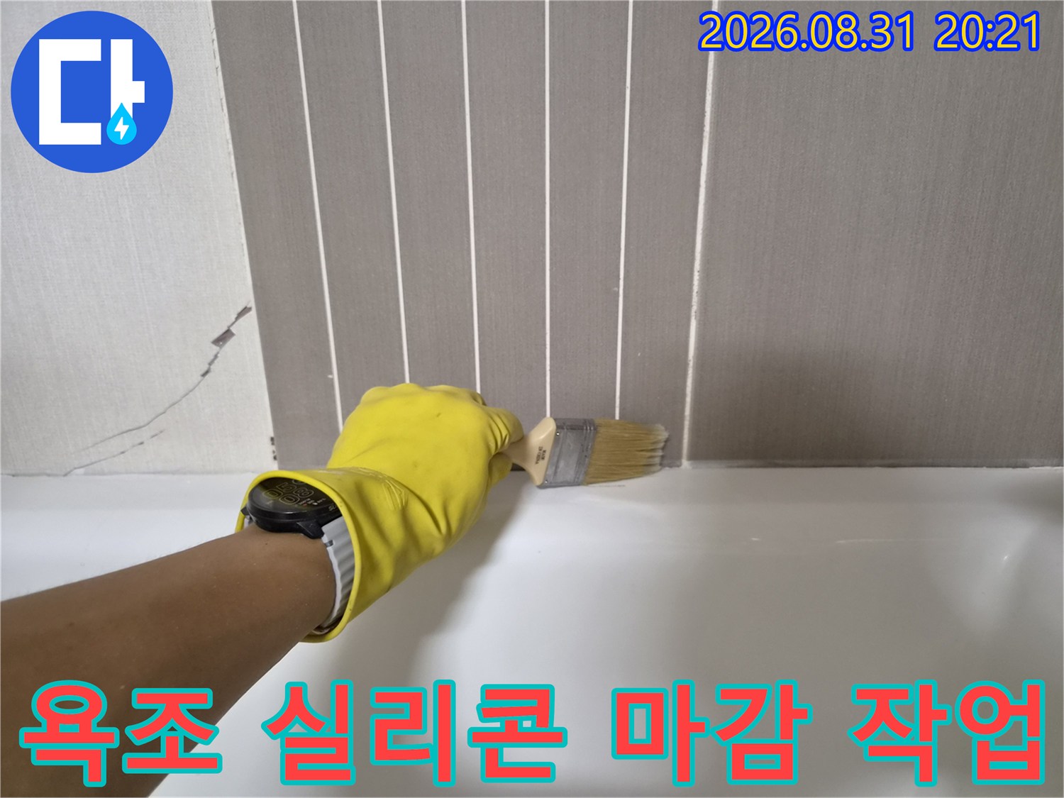 욕조 테두리 틈새를 메우기 위해 브러쉬로 실리콘을 바르는 모습