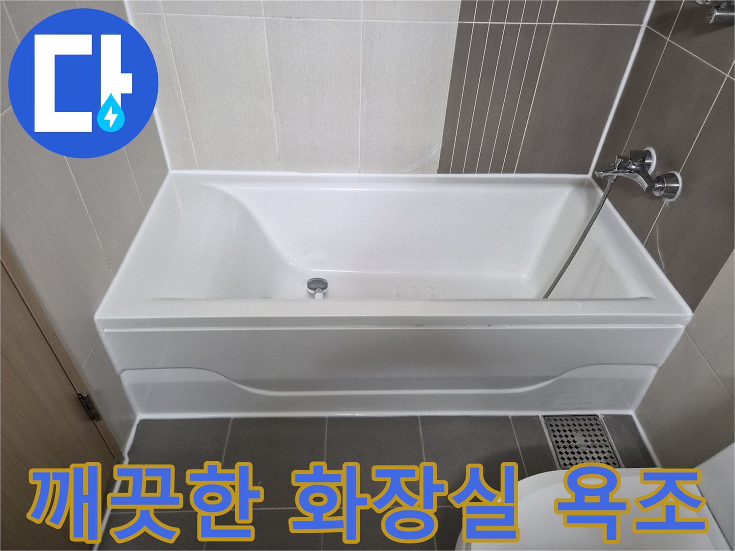흰색 욕조와 회색 타일이 시공된 화장실 내부 모습