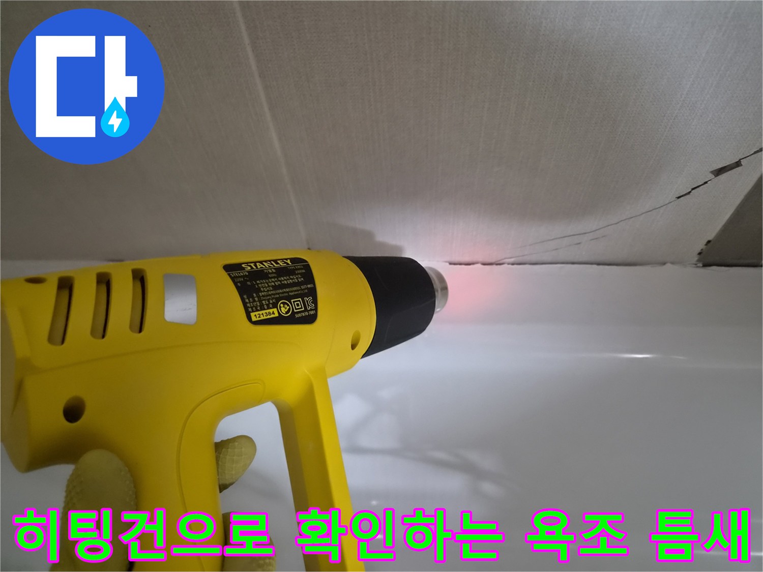히팅건-을-이용하여-욕조와-벽면-사이의-균열을-살피는-모습