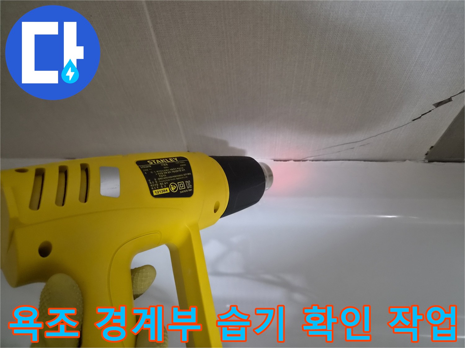 히팅건으로-욕조와 벽체 사이의-습기를 말리며 점검 중