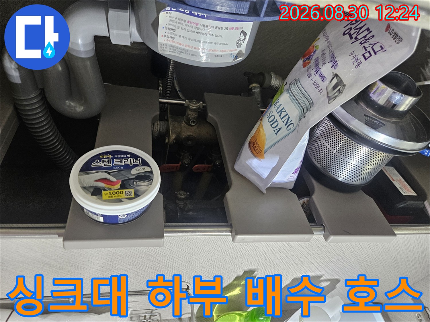 싱크대 아래쪽 굵은 배수관과 연결된 유연한 호스의 모습