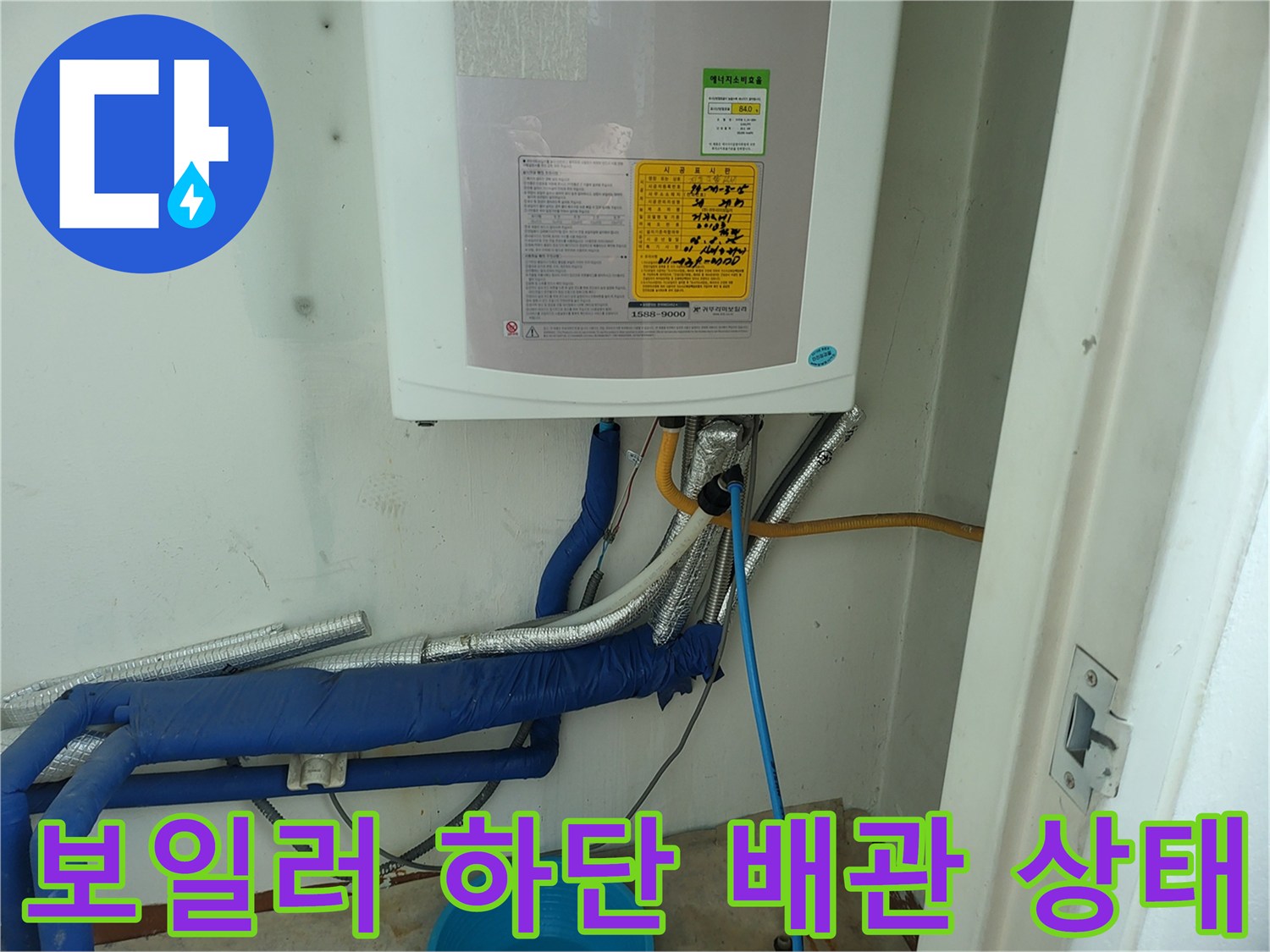 보일러-하단에-연결된-파란색-보온재-배관-및-노출된-연결부