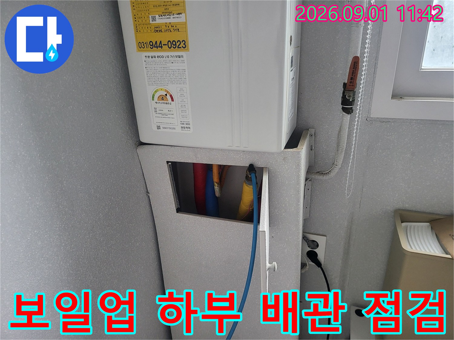 보일러 아래쪽으로 연결된 여러 색상의 급수 및 온수 배관