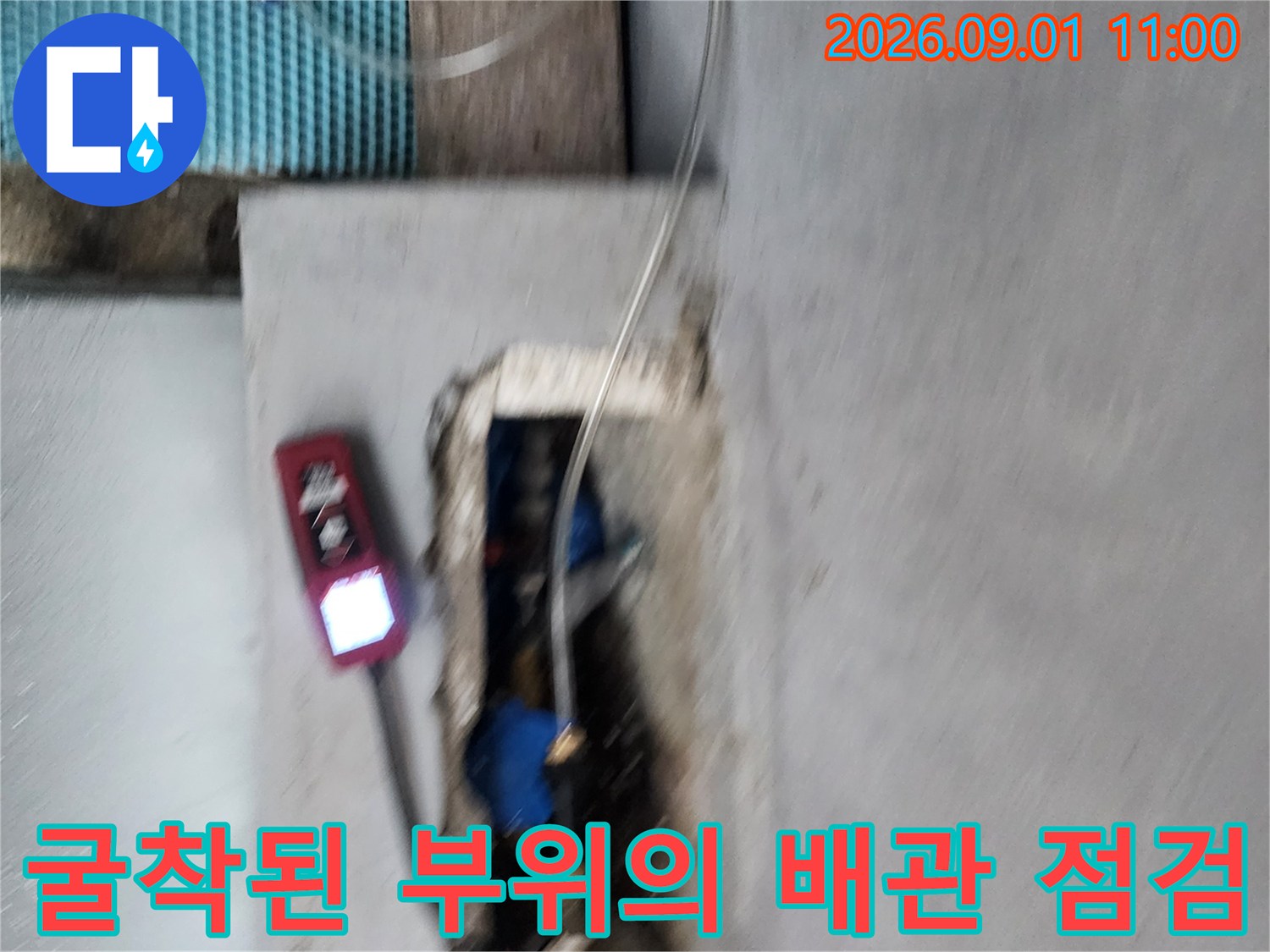 배관 연결 부위 누수를 확인하기 위해 가스 탐지 장비를 사용하는 장면입니다.