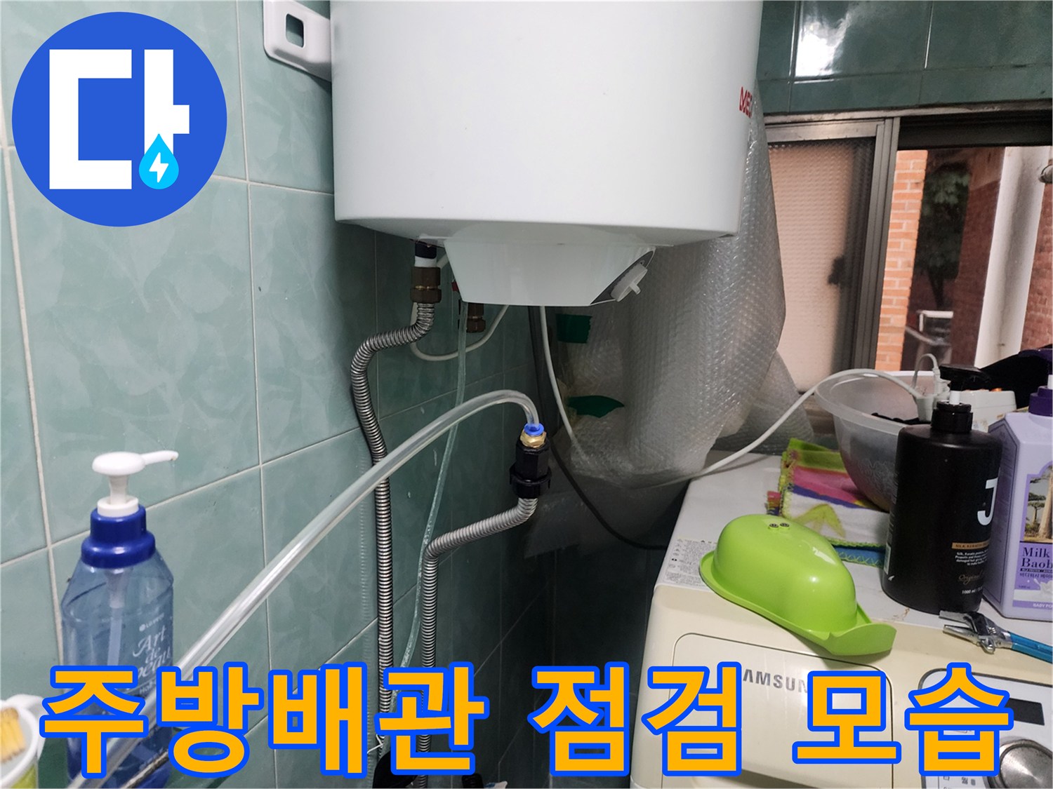 주방 벽면 수도 배관과 연결 부위를 확인하는 장면입니다.