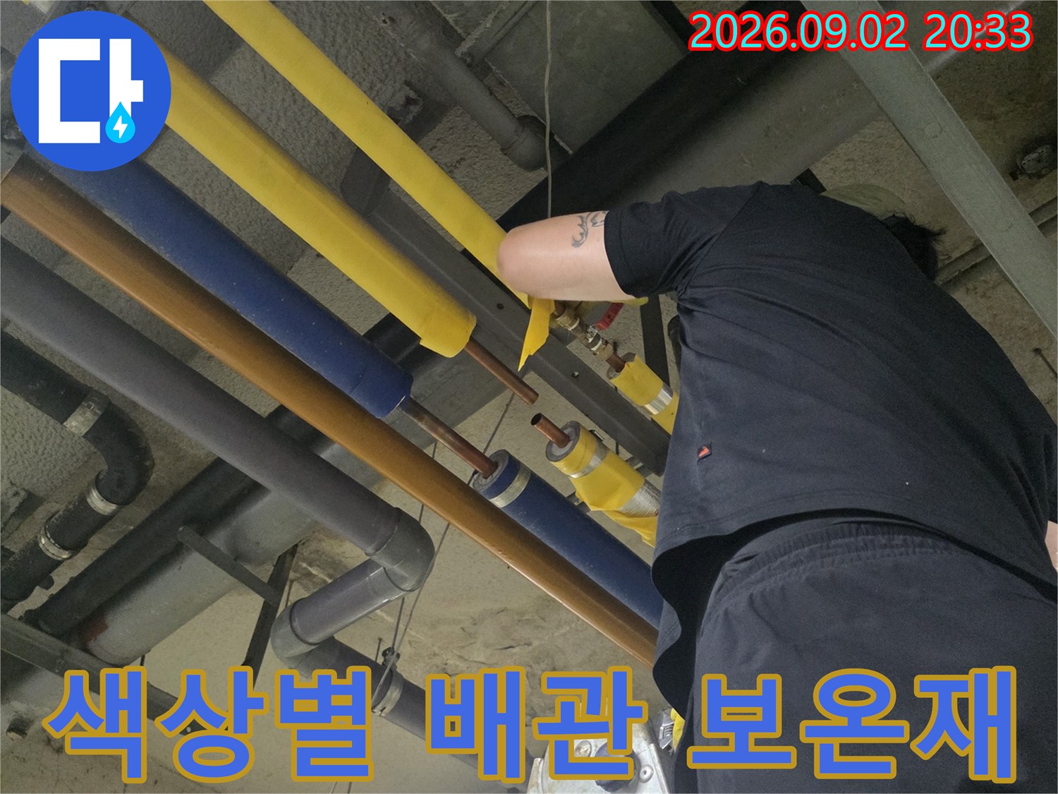 노란색 및 파란색 보선재로 감싸진 천장 설비 배관