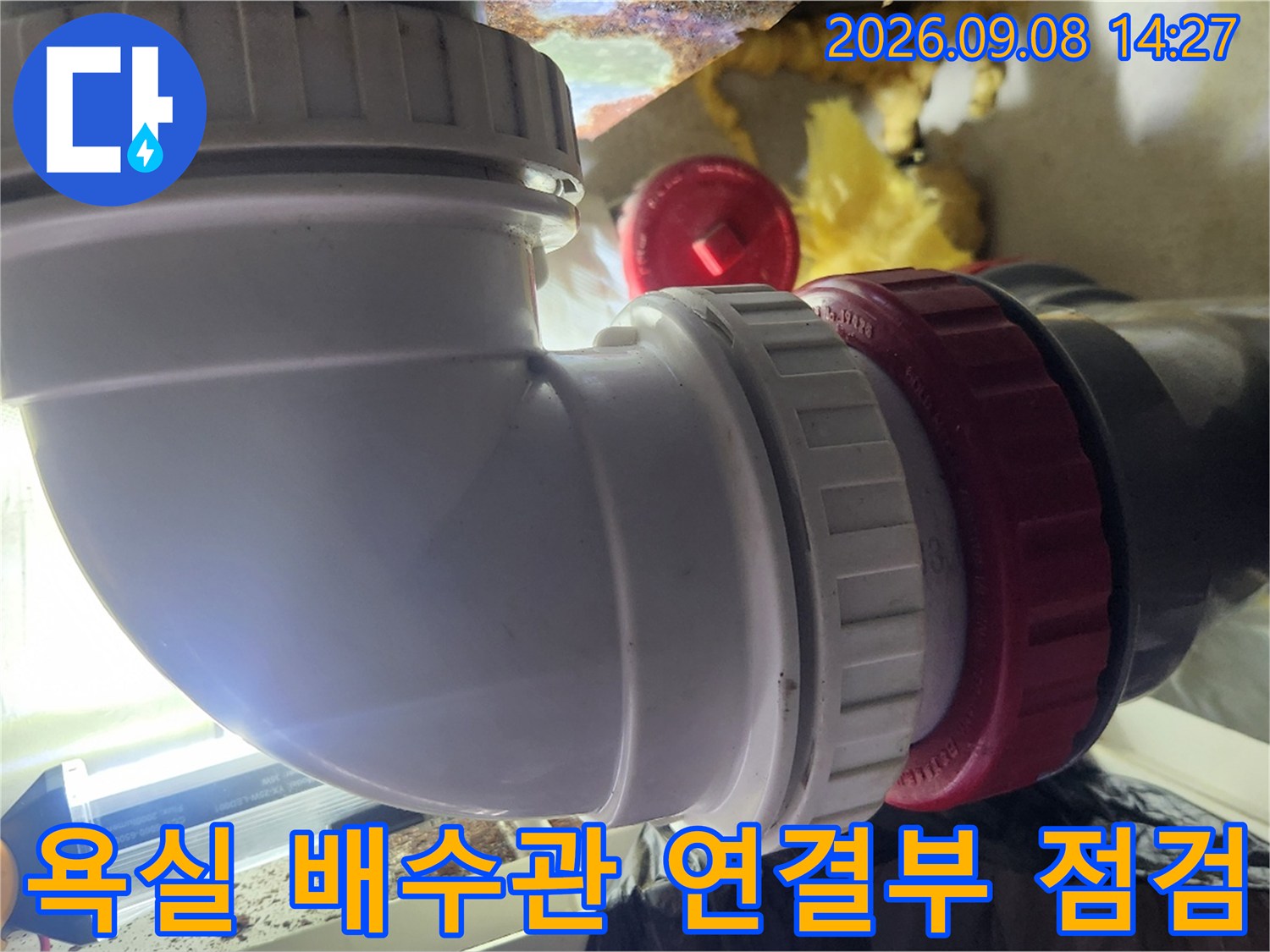 하얀색 PVC 배관과 붉은색 소켓의 연결 상태를 확인하는 모습