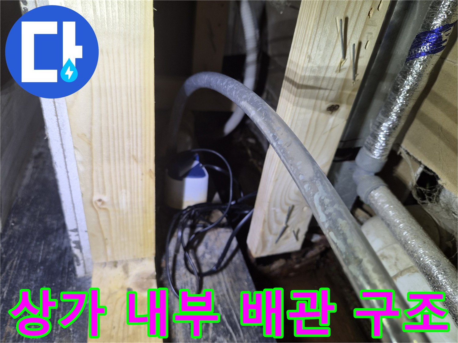 복잡하게 얽힌 천장 내부 배관과 목재 지지대 모습