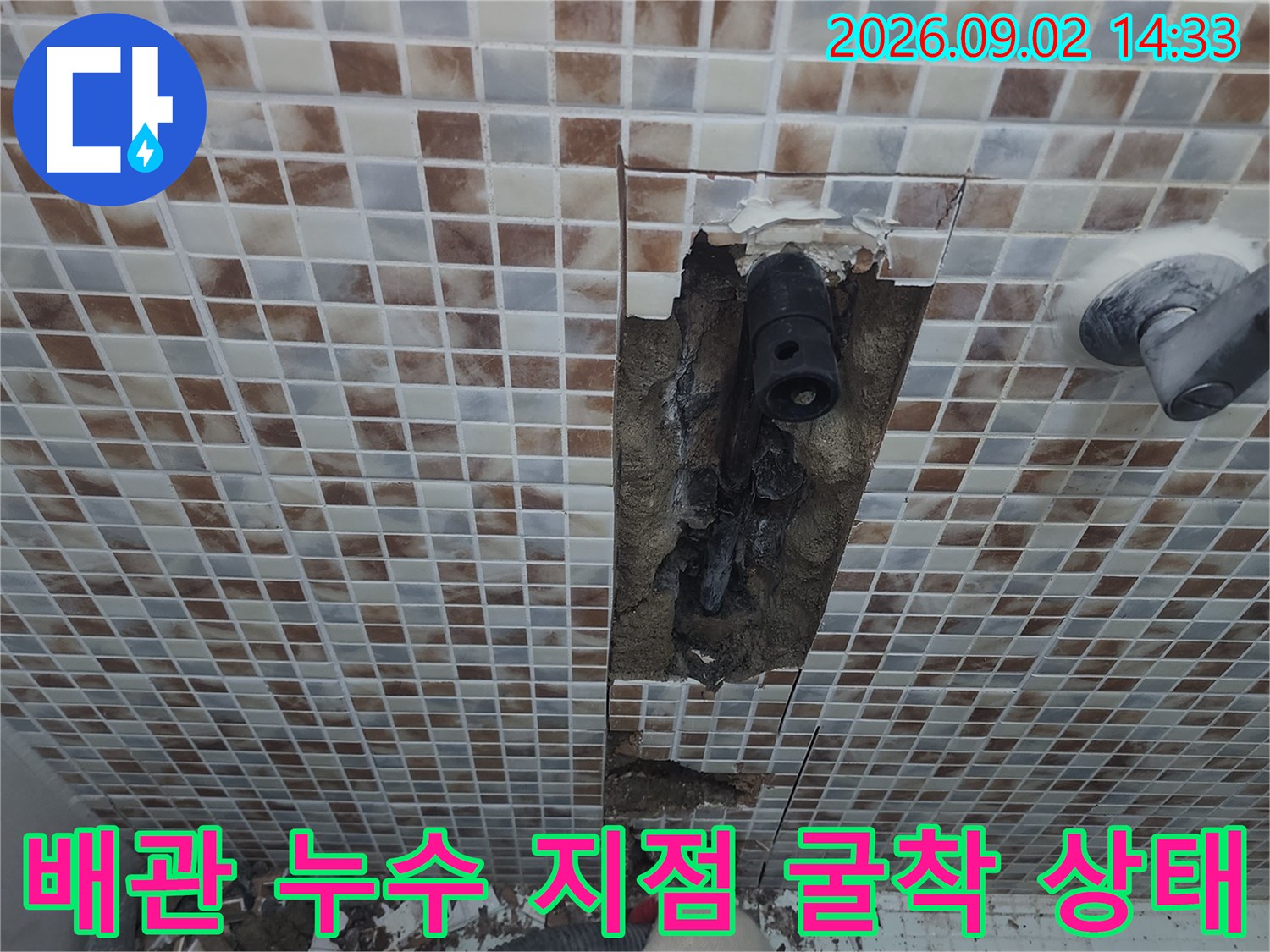 타일을 제거한 벽면 내부의 배관과 굴착된 콘크리트 파편