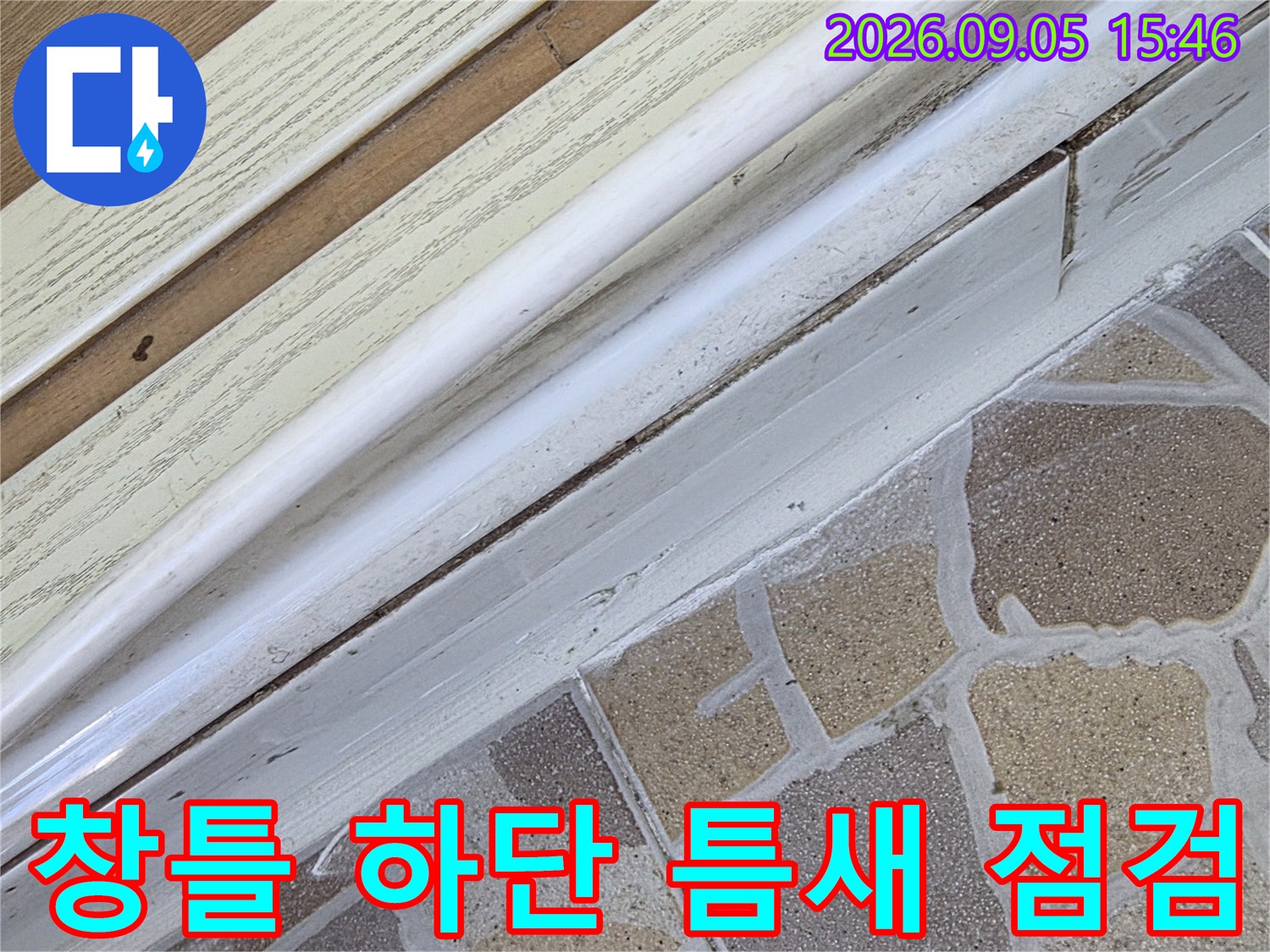 샤시 프레임과 타일 벽면이 만나는 지점의 근접 사진입니다.