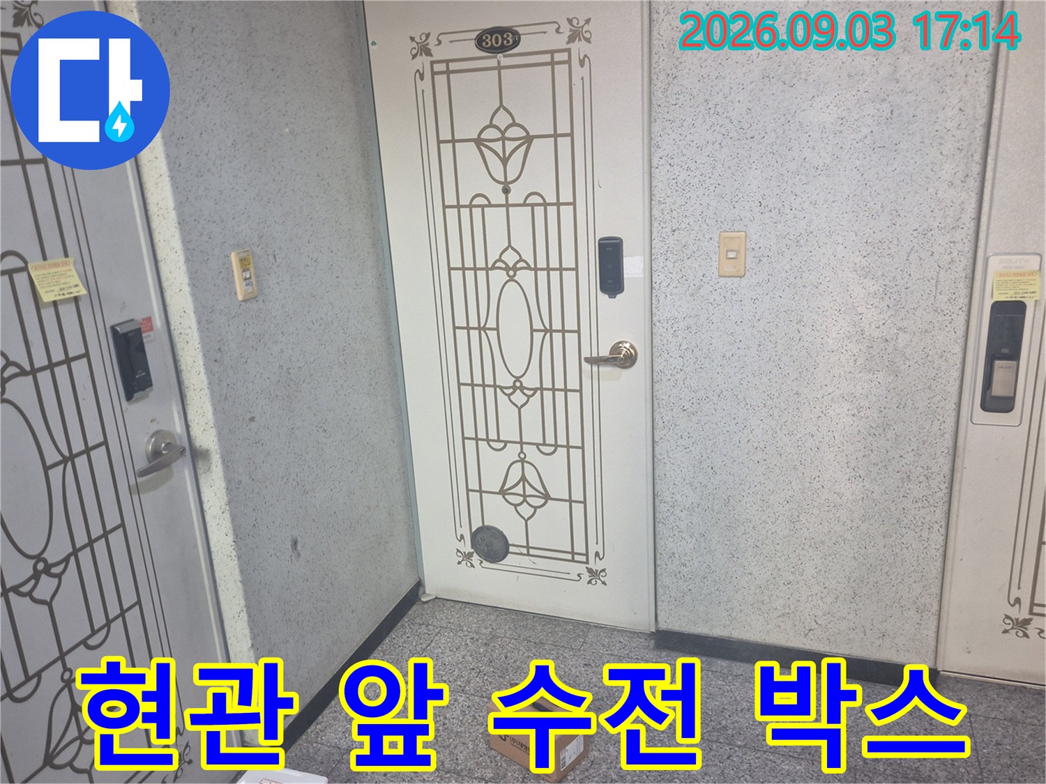 아파트 현관문과 그 앞에 놓인 교체용 자재 상자